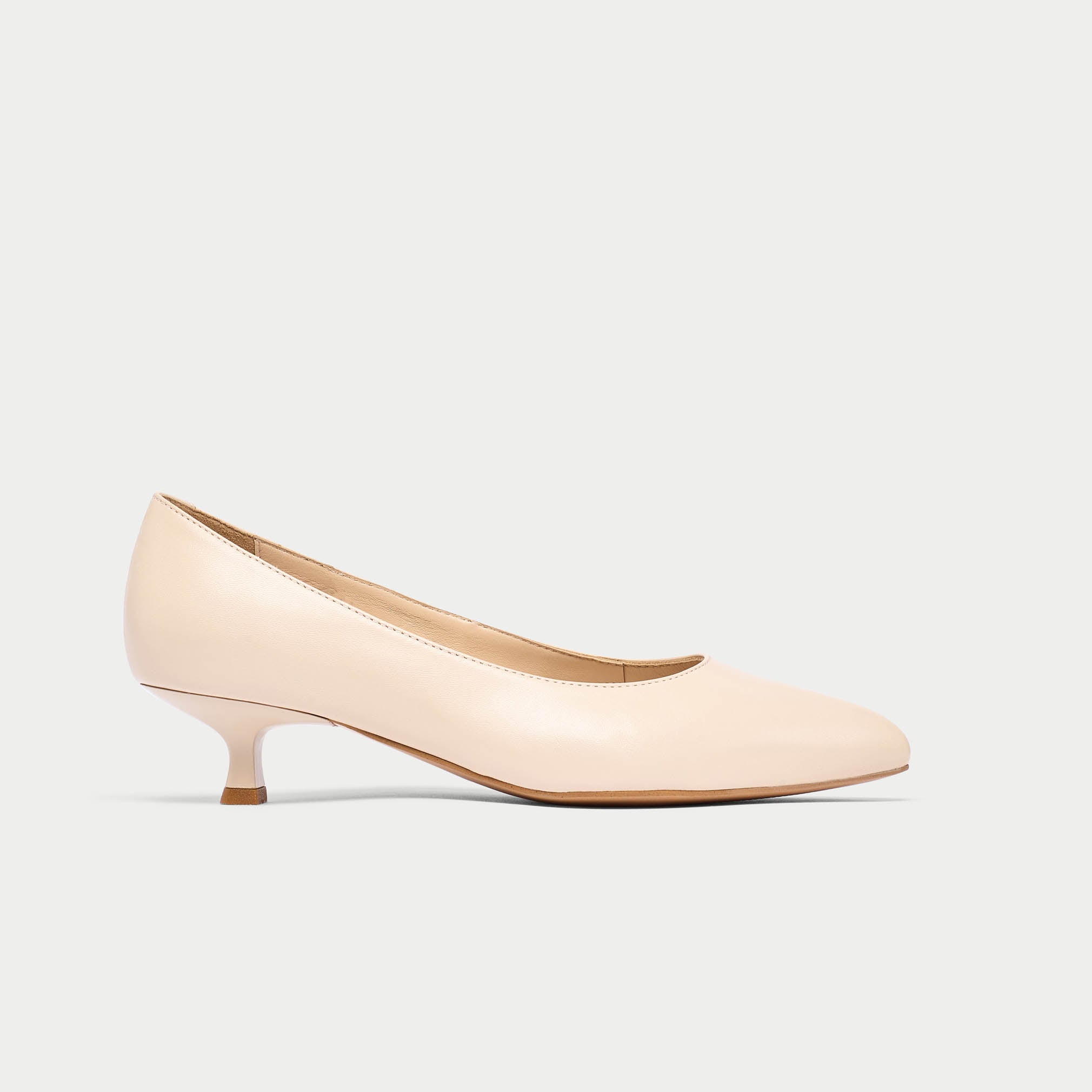 Nude-colored kitten heel shoe on a light gray background