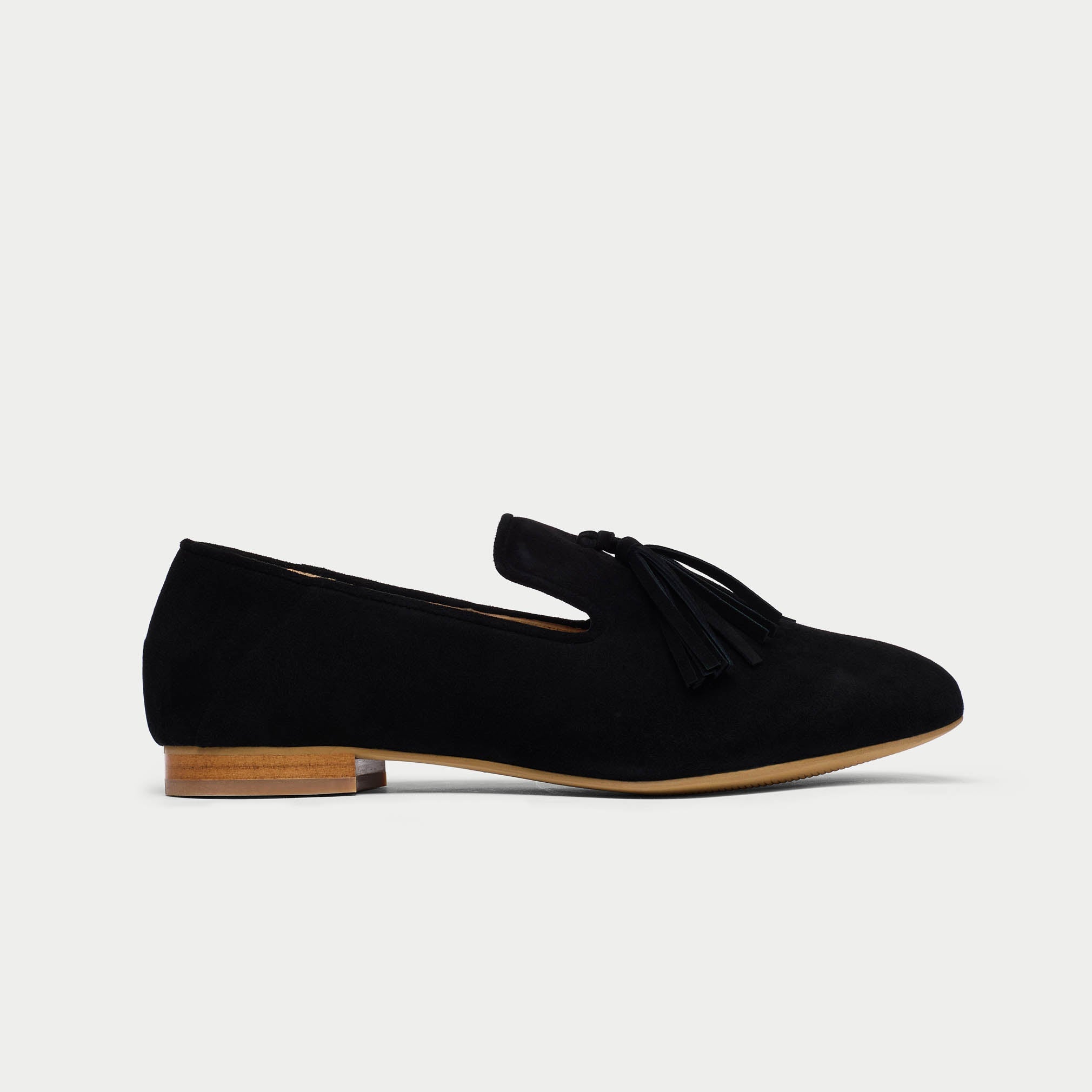 Black suede loafer shoe on a light gray background