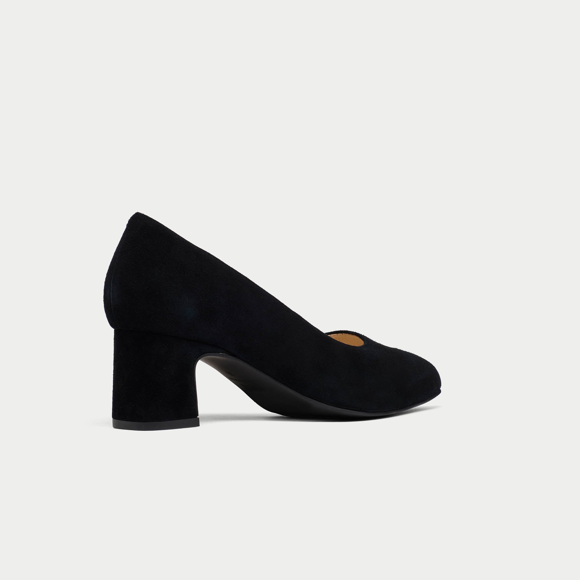 Black suede shoe on a light gray background