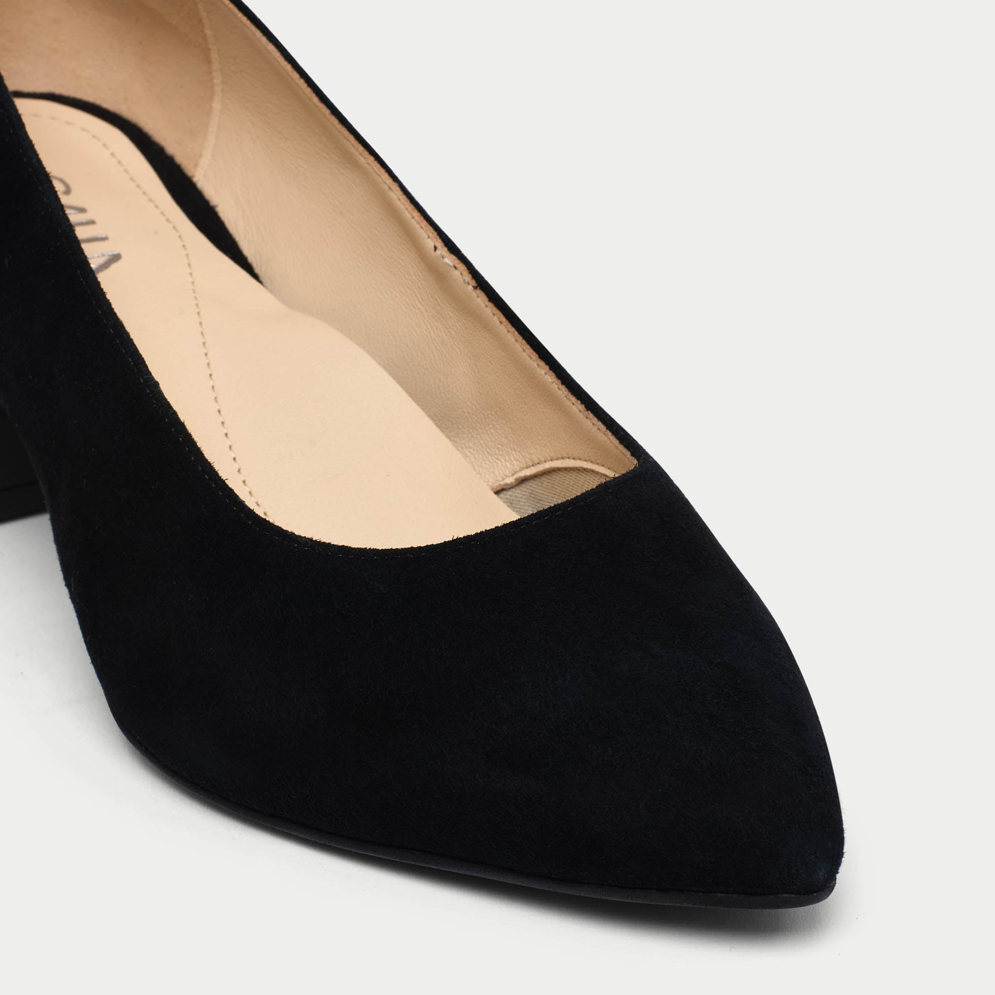 Black suede shoe on a light gray background