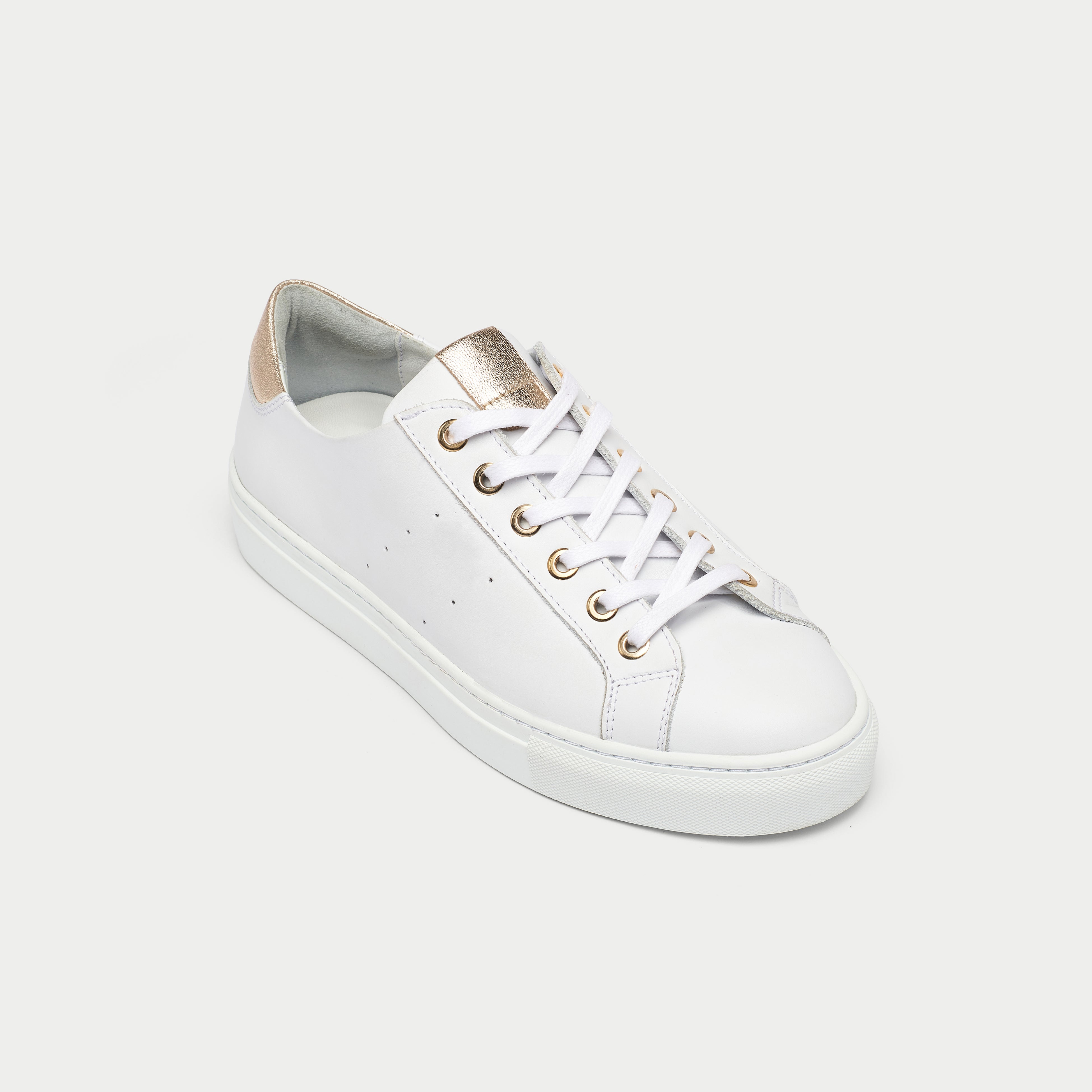 White sneaker with gold accents on a white background