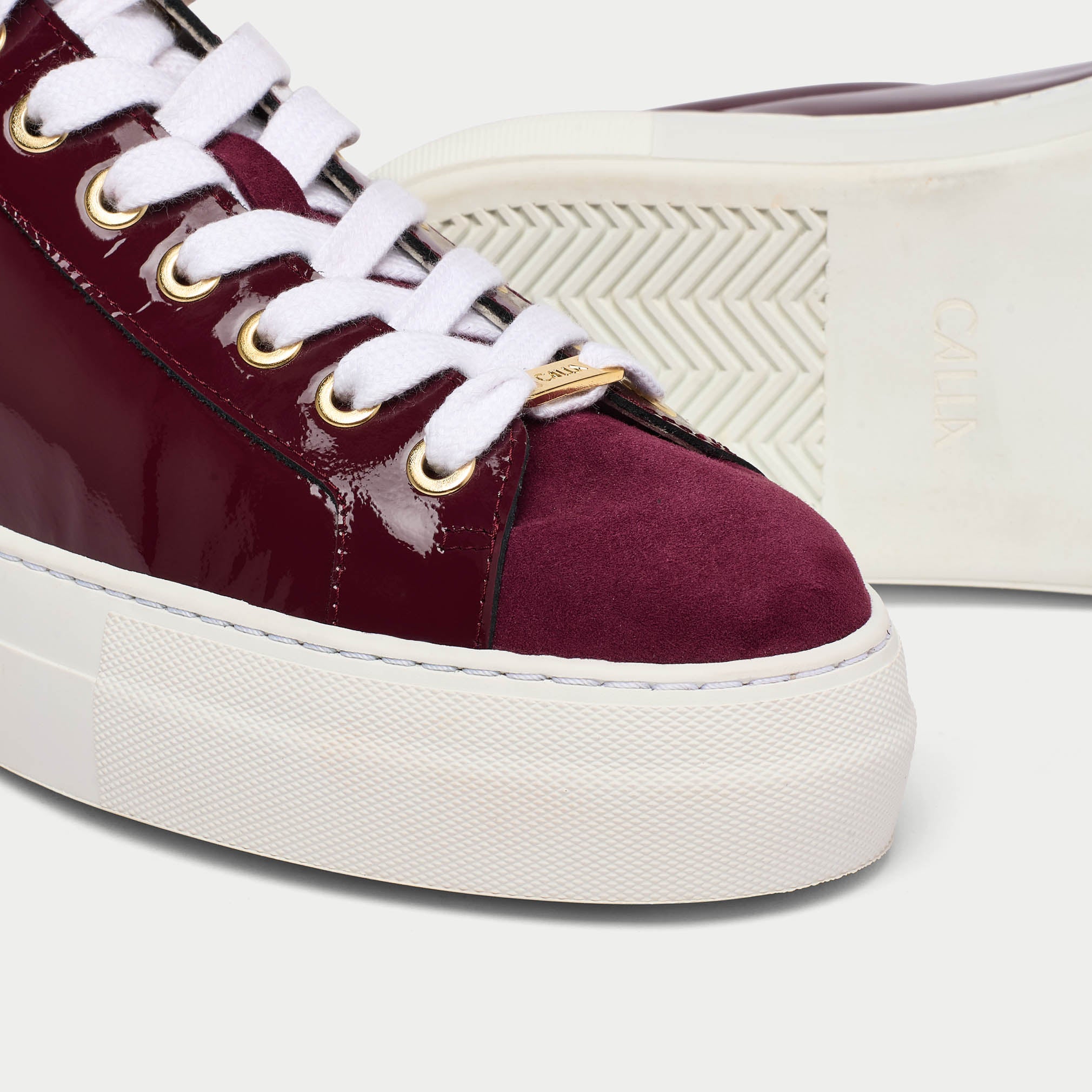 Saturn burgundy patent leather trainer tip close up