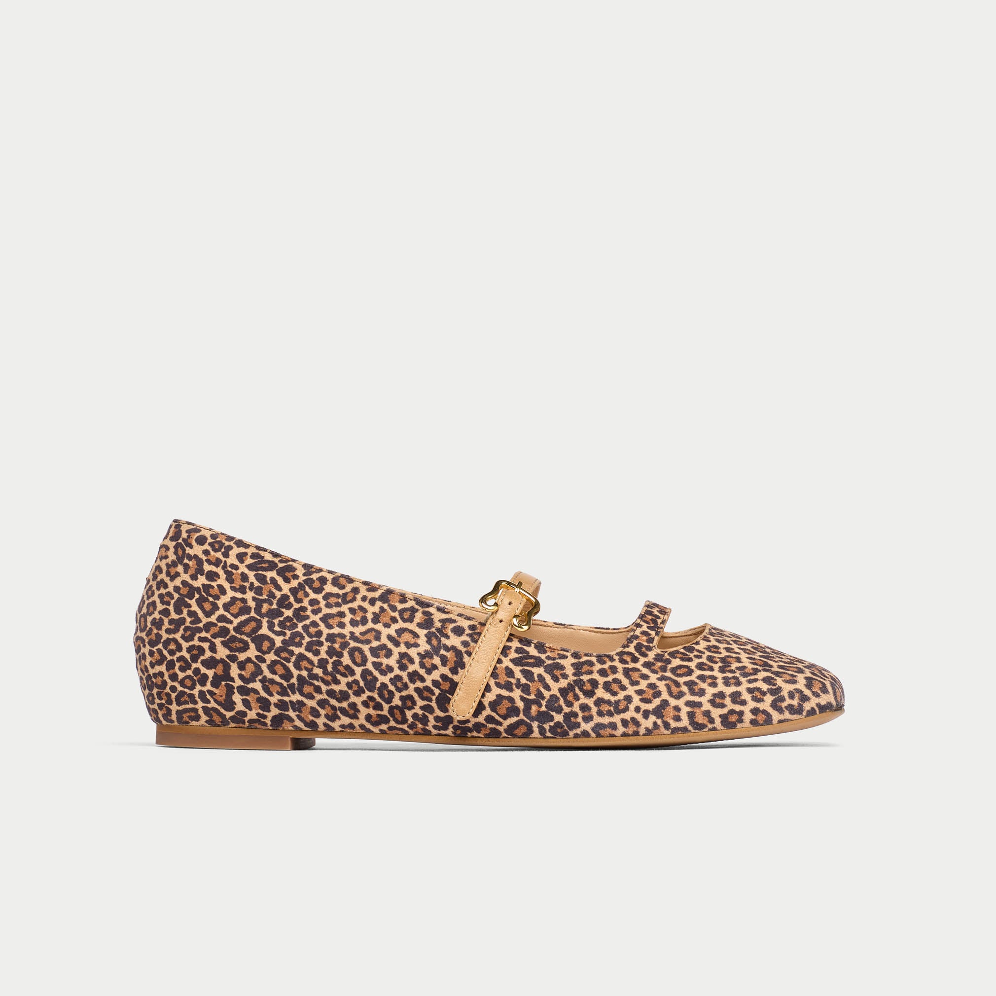 Leopard print flat shoe with a beige strap on a light gray background