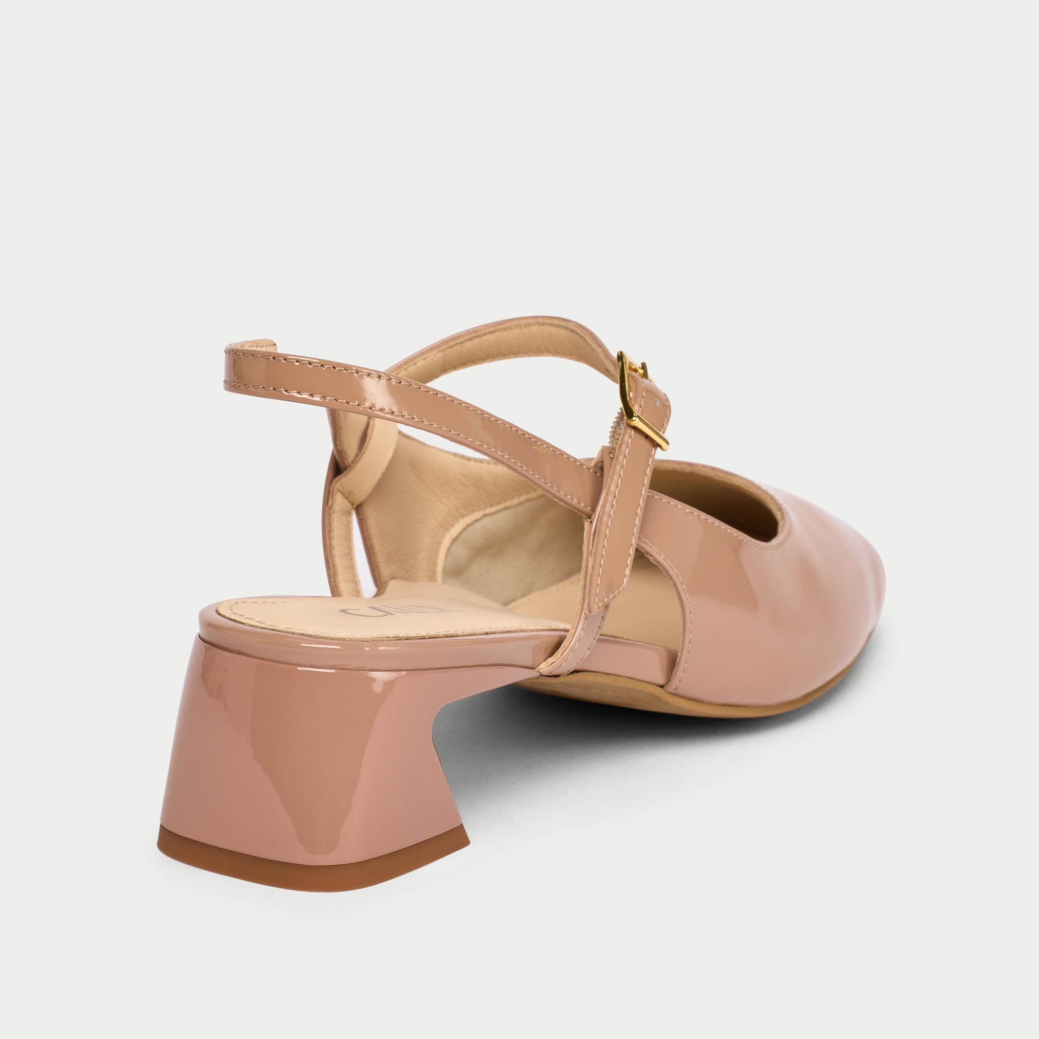 Pink low-heeled shoe with a strap on a light gray background