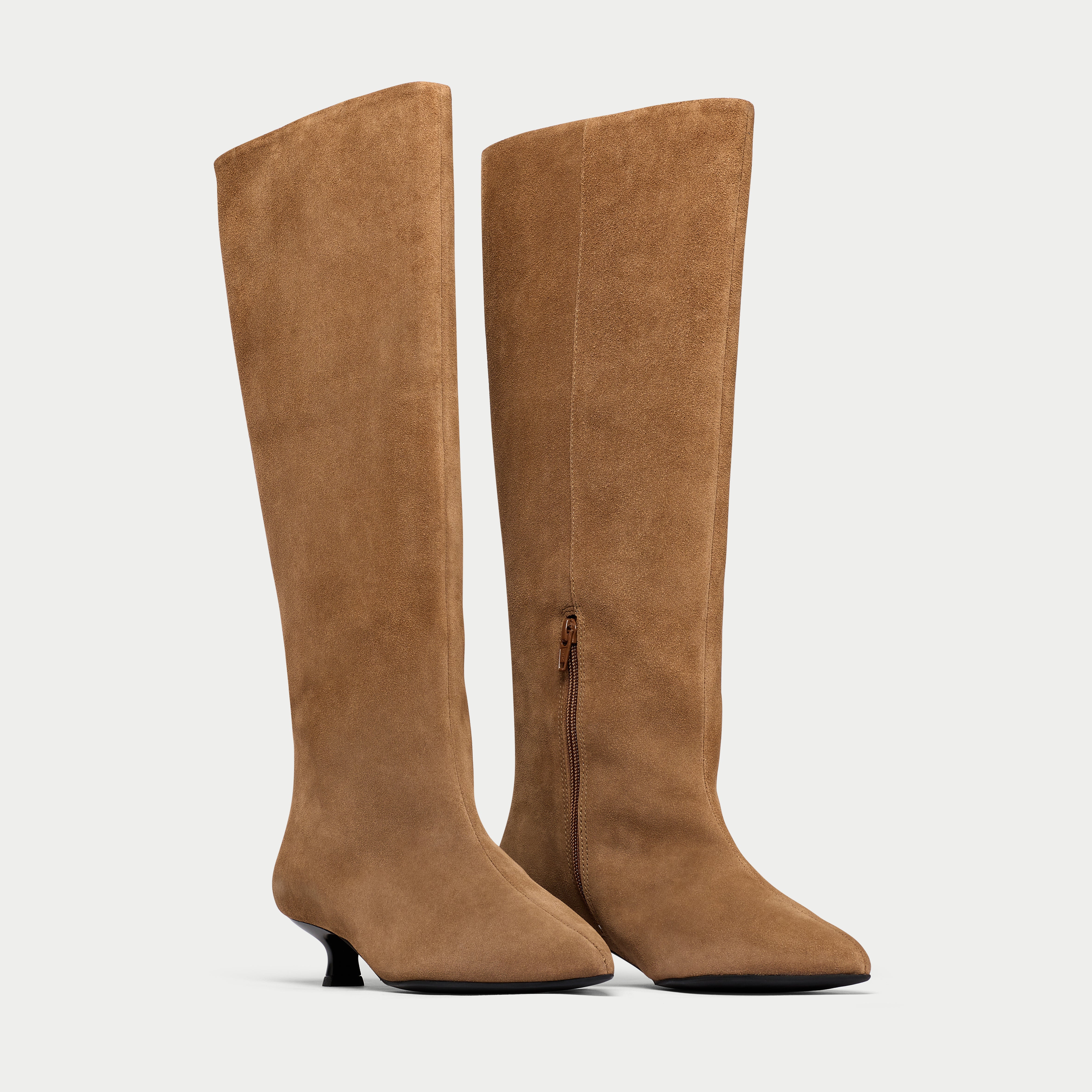 Pair of brown knee-high boots on a light gray background