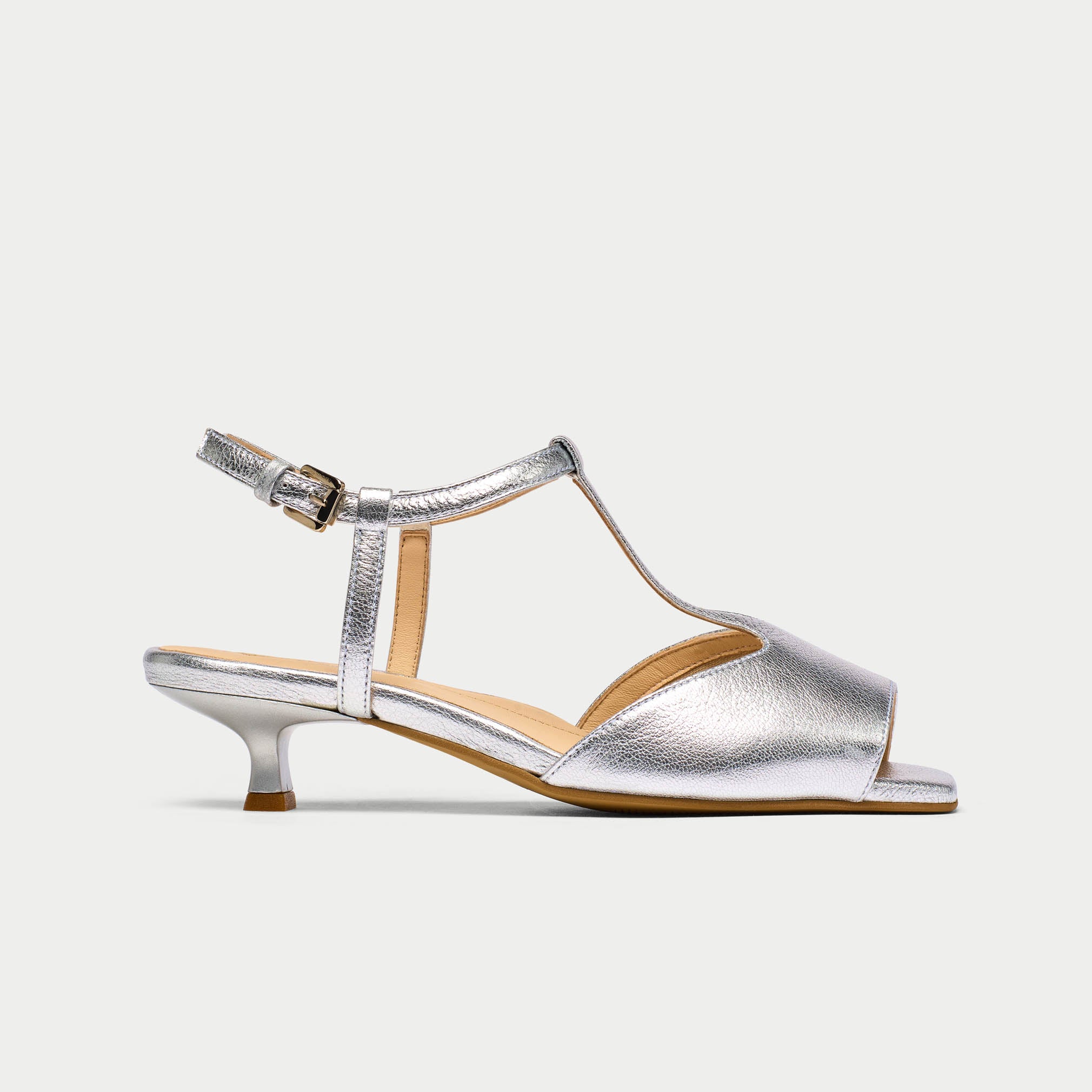 Silver sandal with open toe and kitten heel on a light gray background