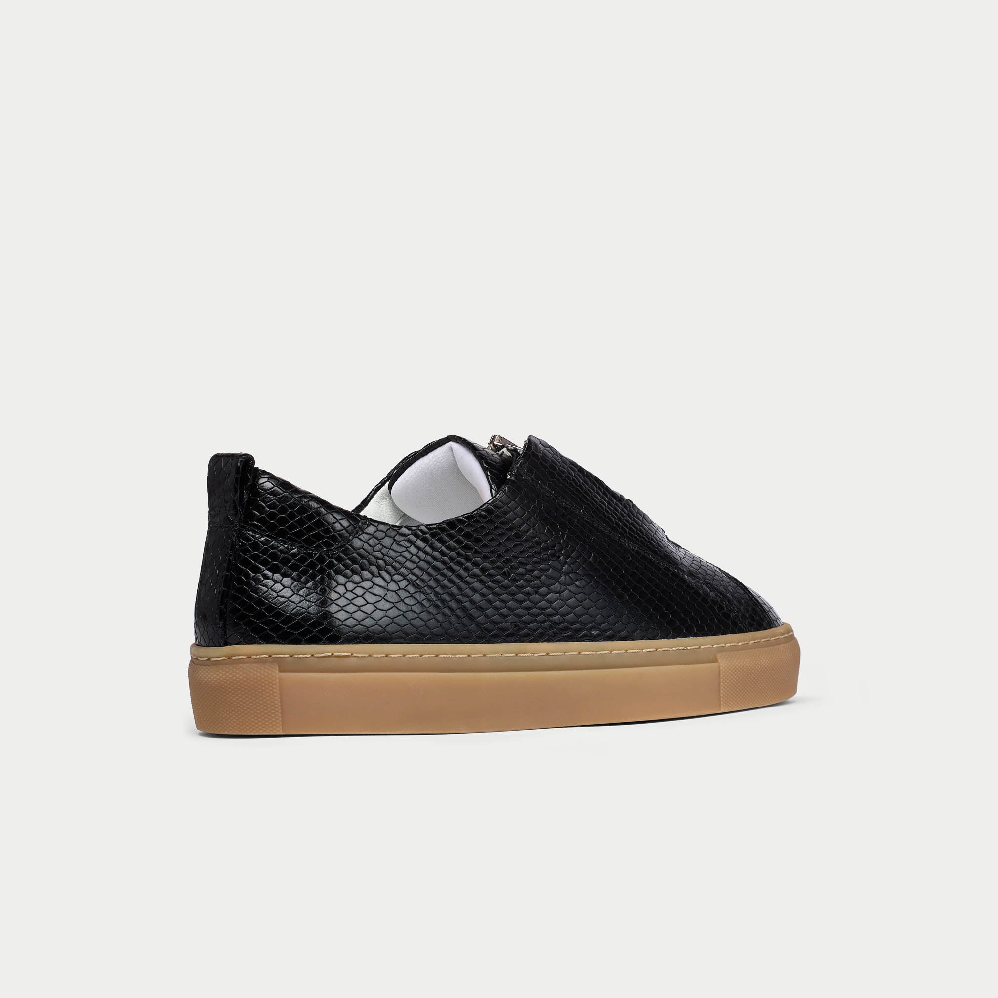 Black Estella sneaker with a brown sole on a light gray background