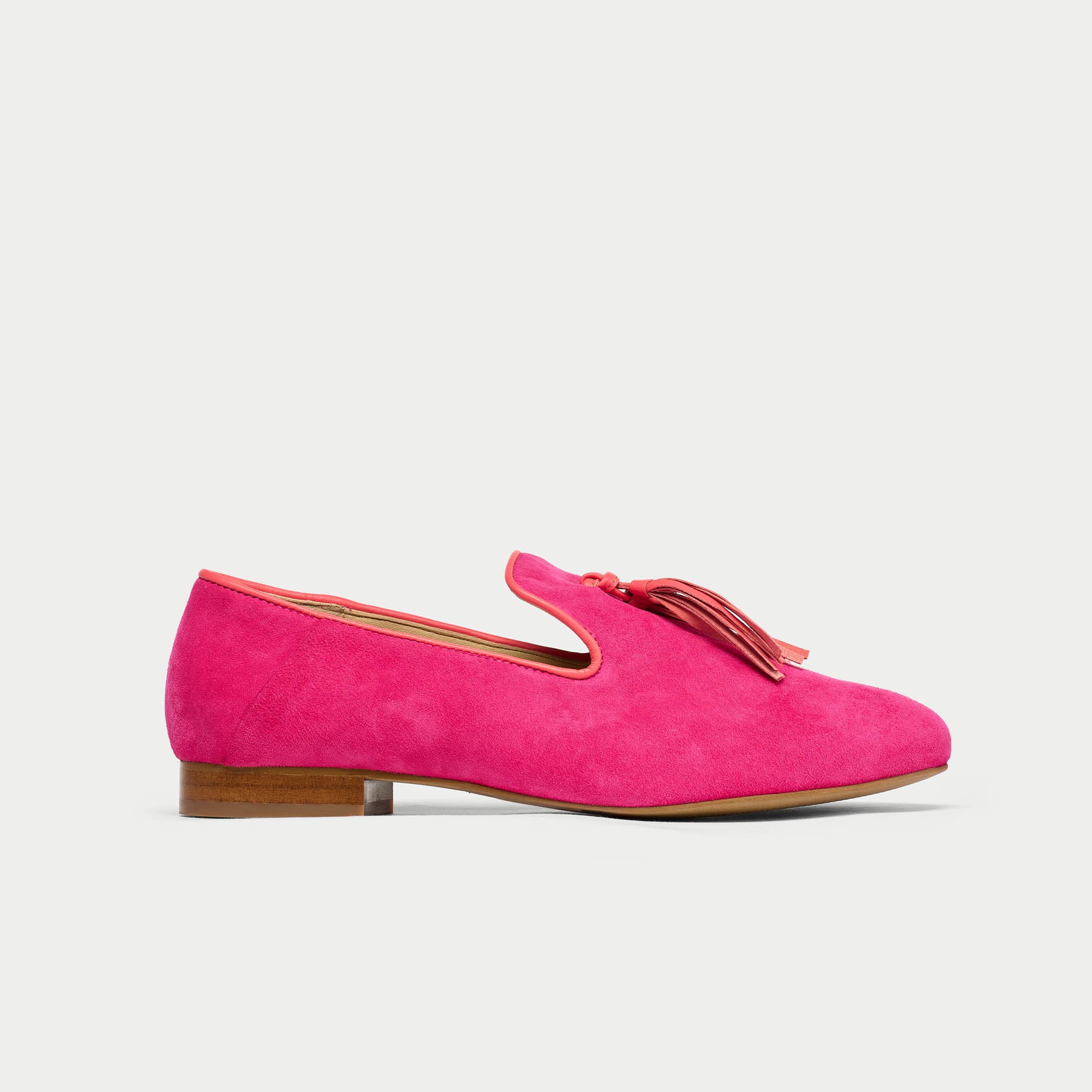 Pink loafer with a tassel on a light gray background