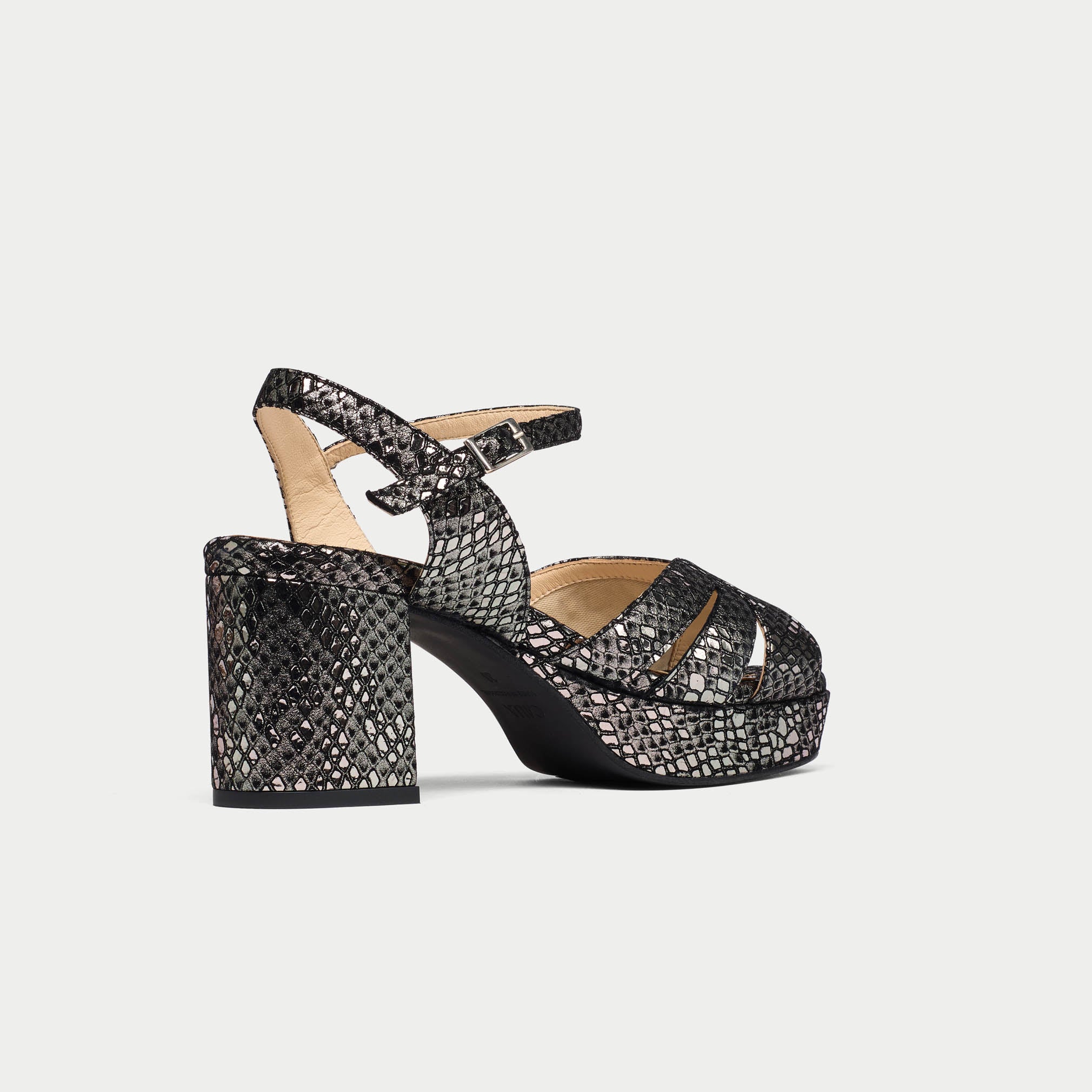 Black and silver patterned high-heeled shoe on a light gray background