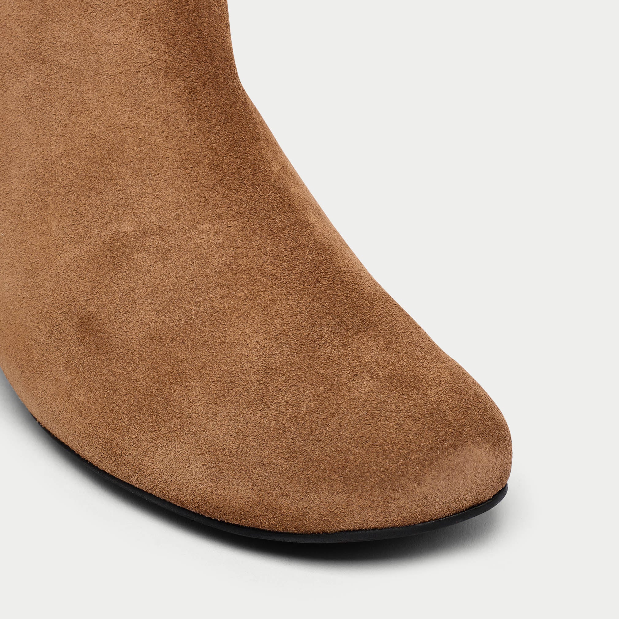 Brown suede boot on a light gray background