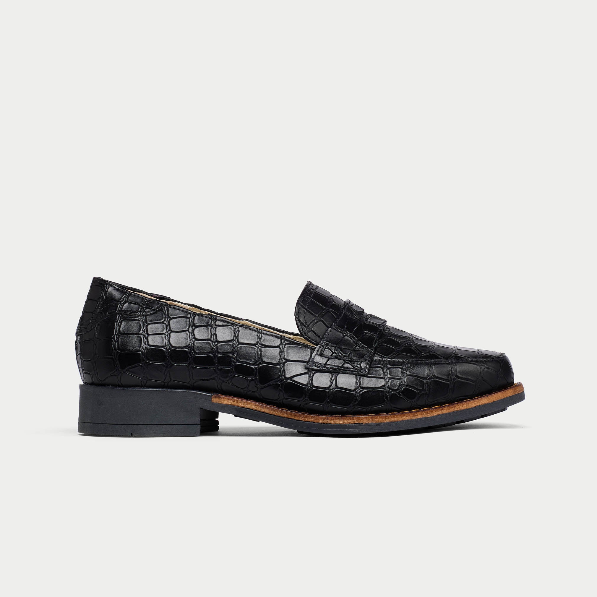 Black crocodile-patterned loafers on a light gray background