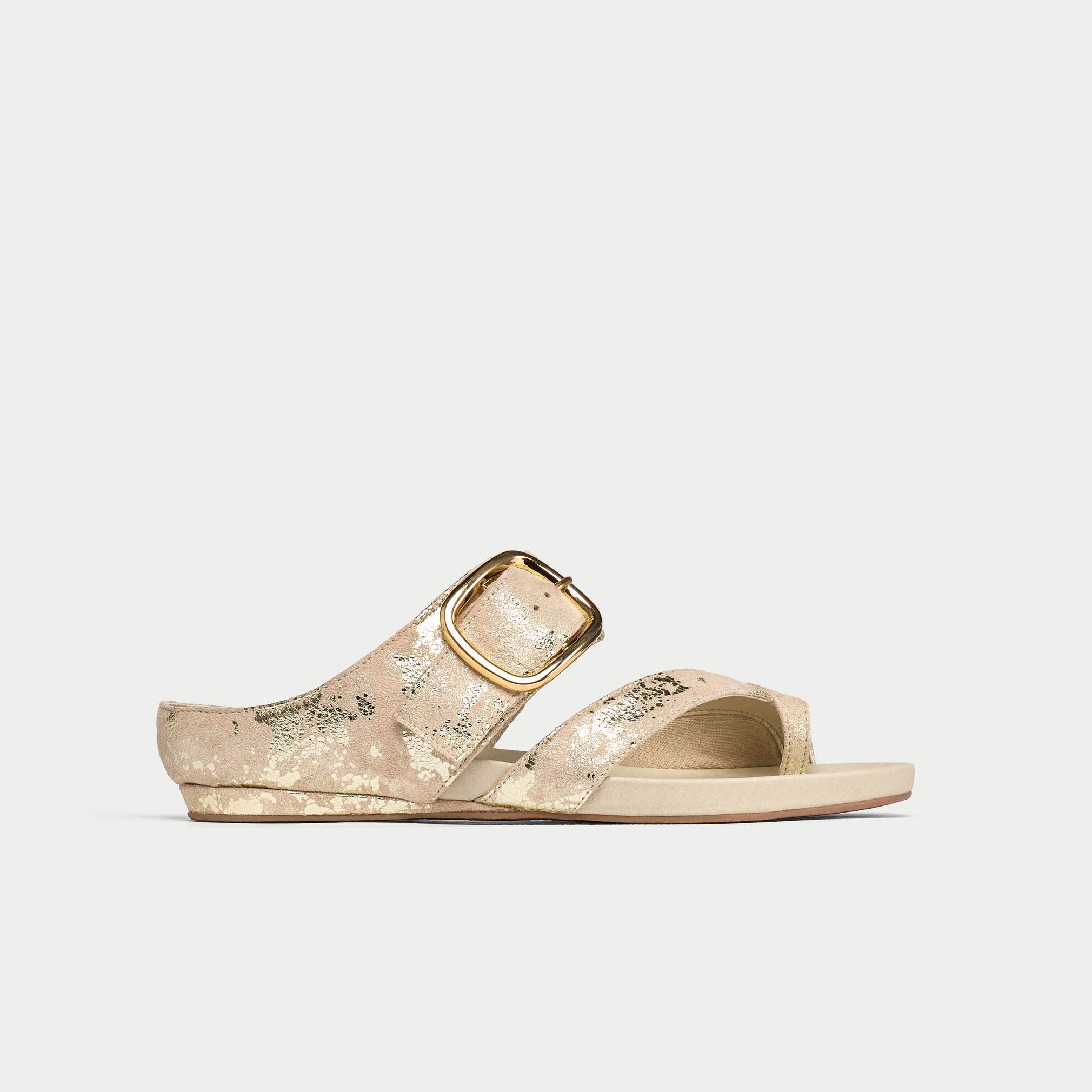 Gold sandal with a buckle on a light gray background