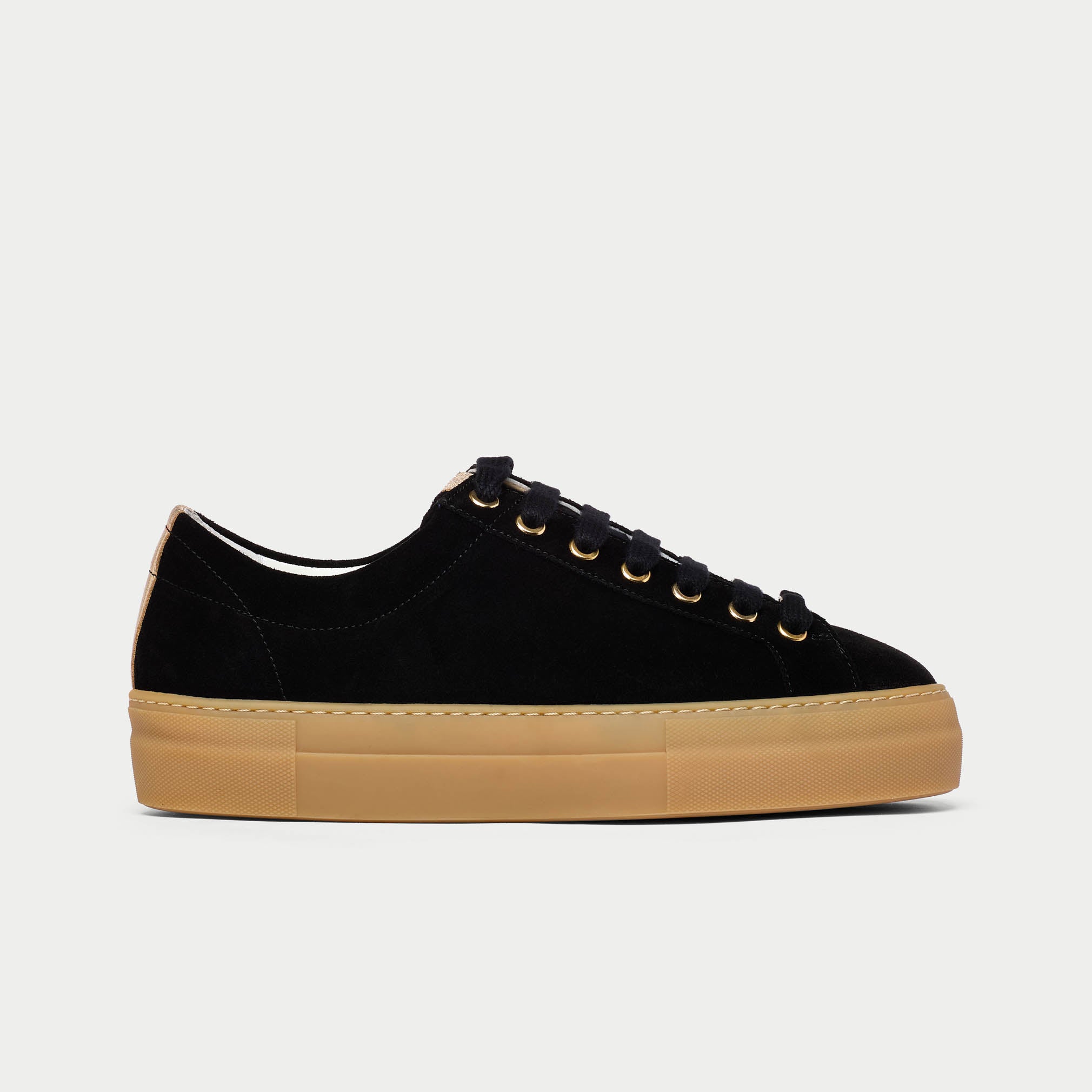 Black sneaker with tan sole on a light gray background