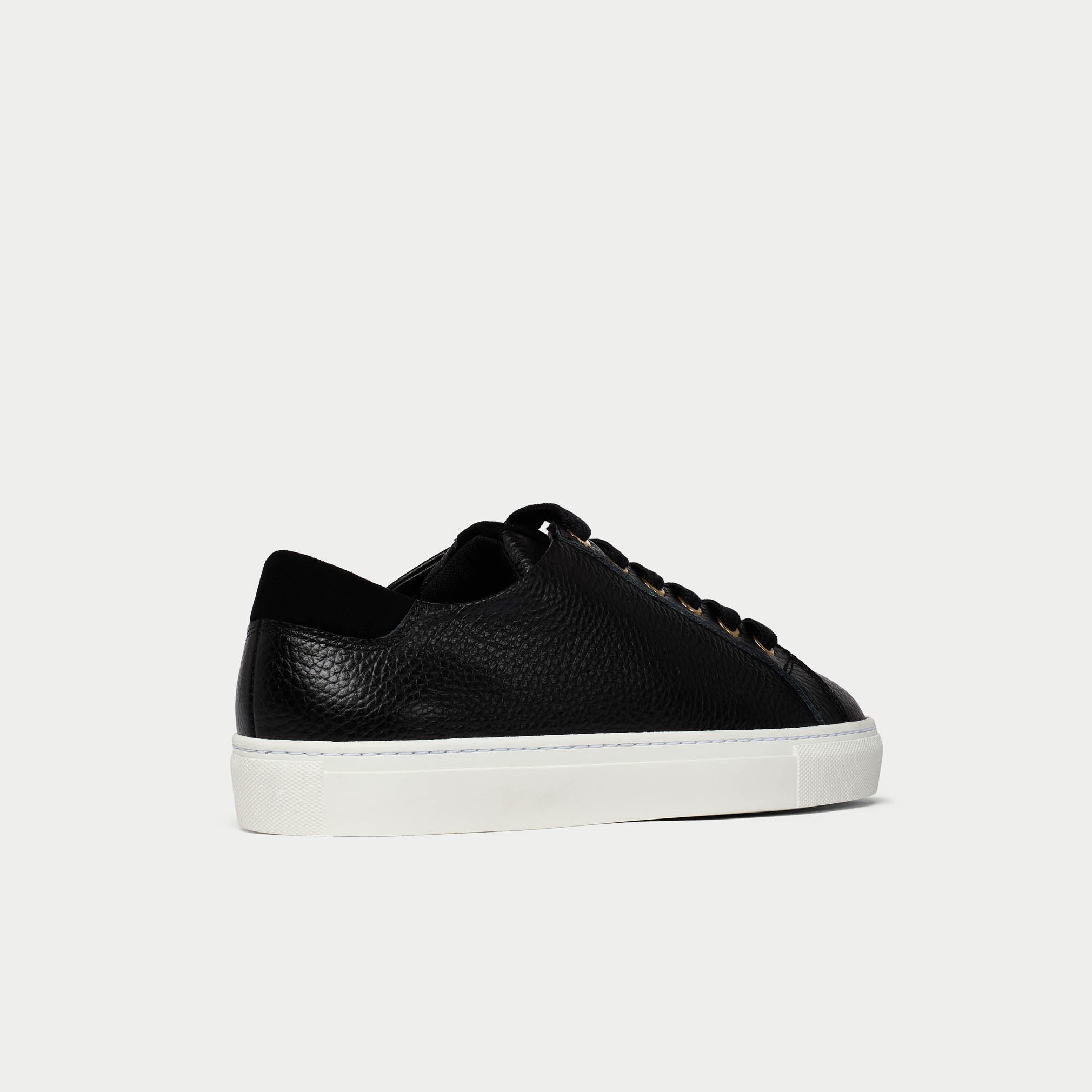 Black leather sneaker on a light gray background