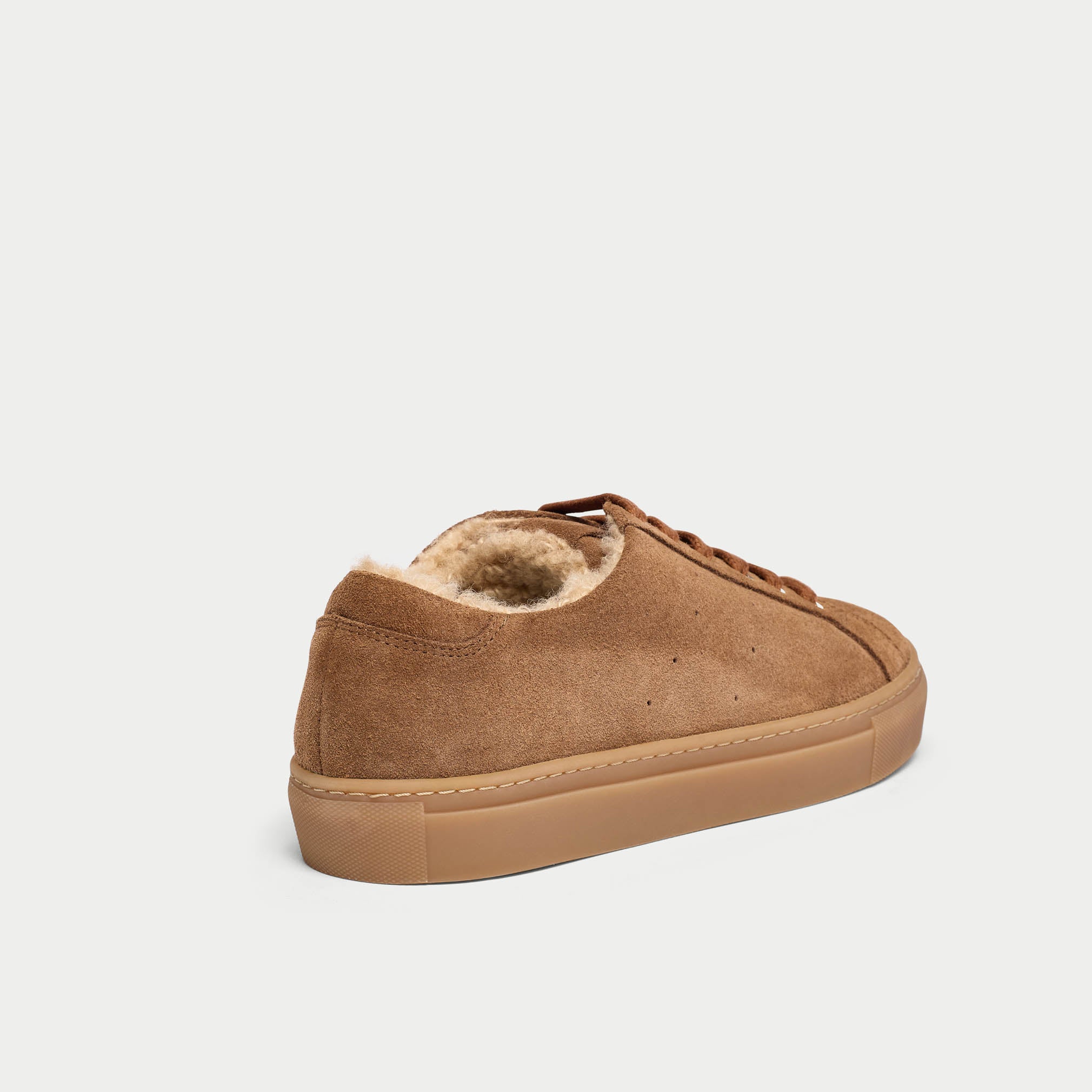 Brown suede sneaker with fur lining on a white background