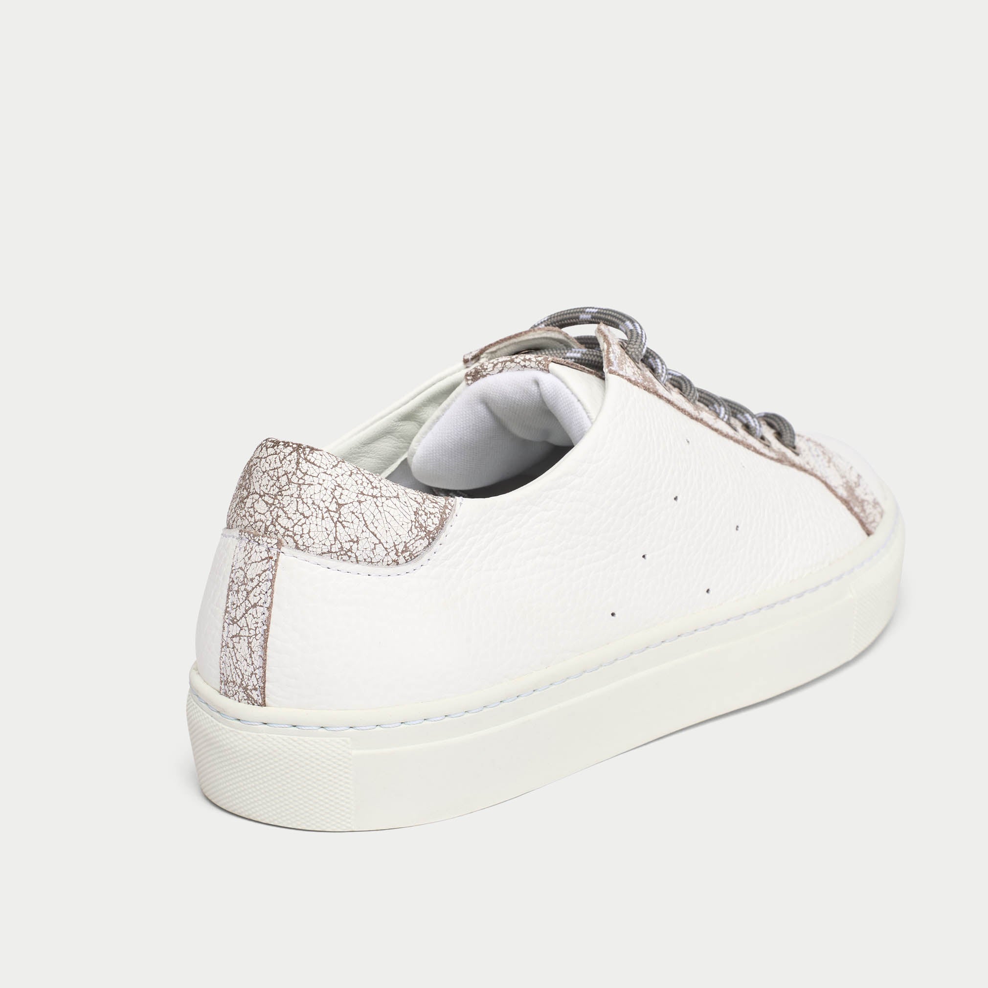 White sneaker with grey crackle heel tab on a light gray background