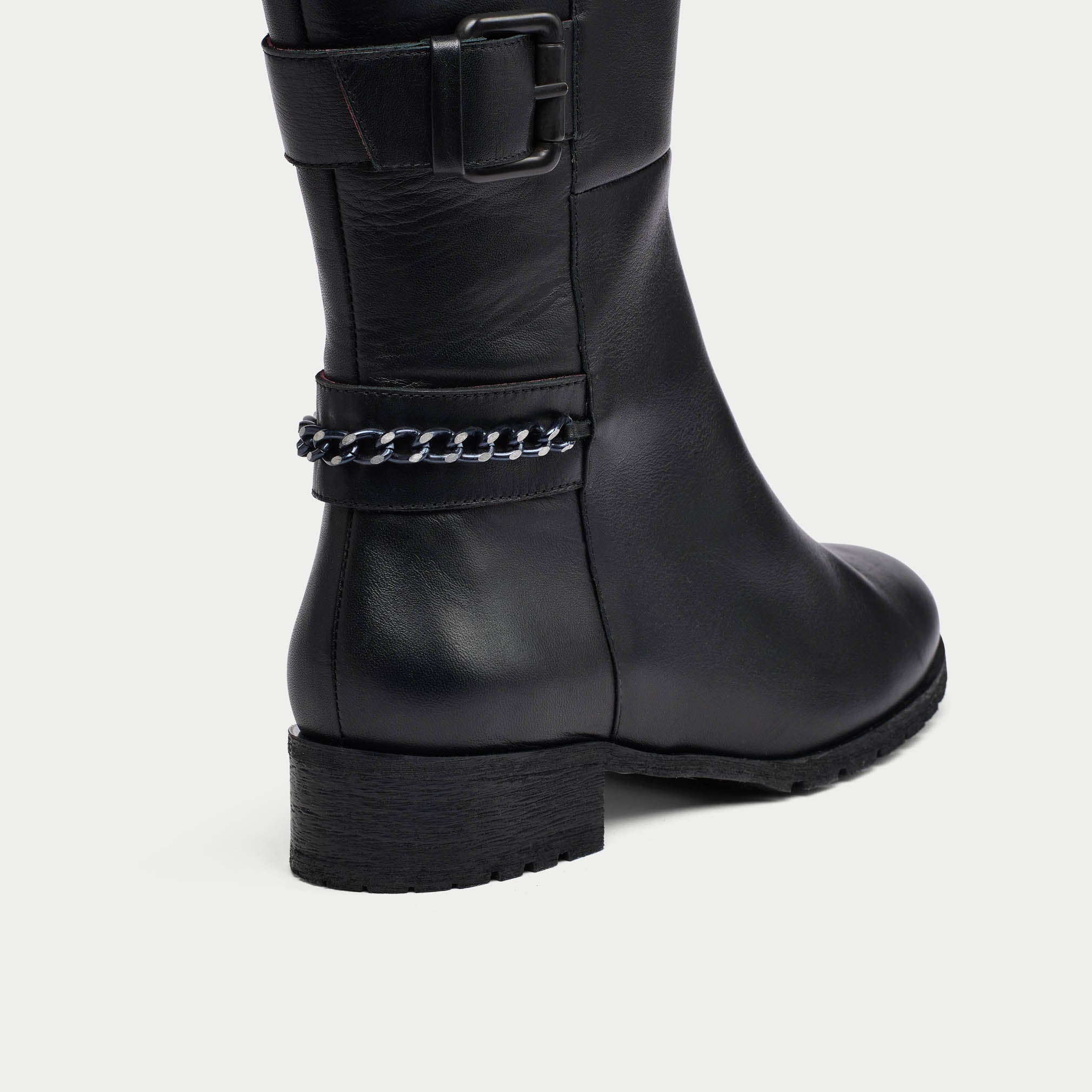 Black leather boot with chain detail on a white background