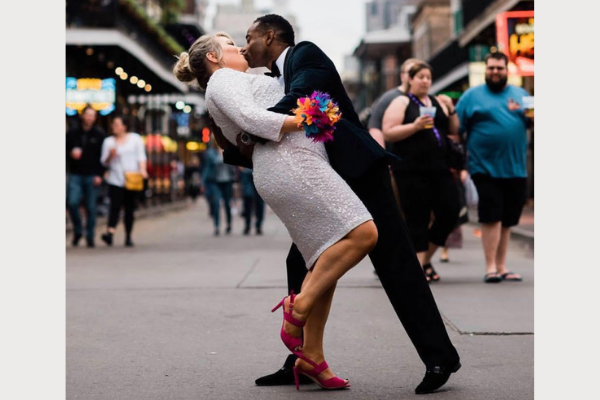 woman kissing a man in the street during a wedding