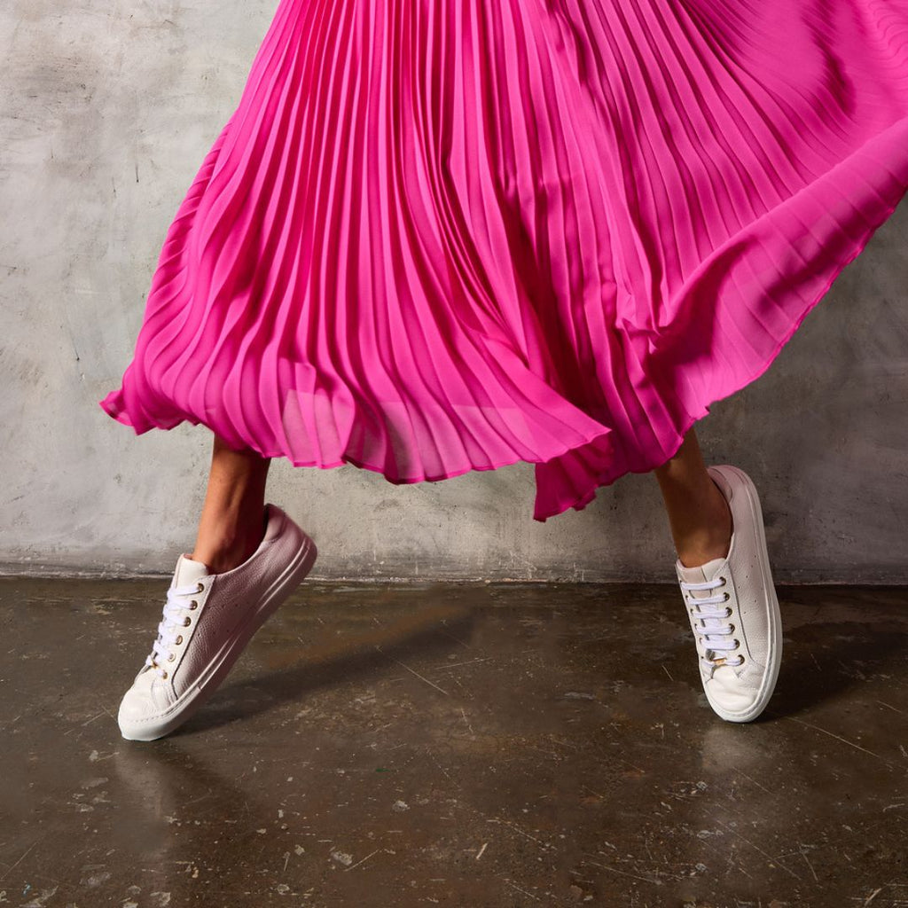 Woman walking in white Calla wide-fit trainers with arch support