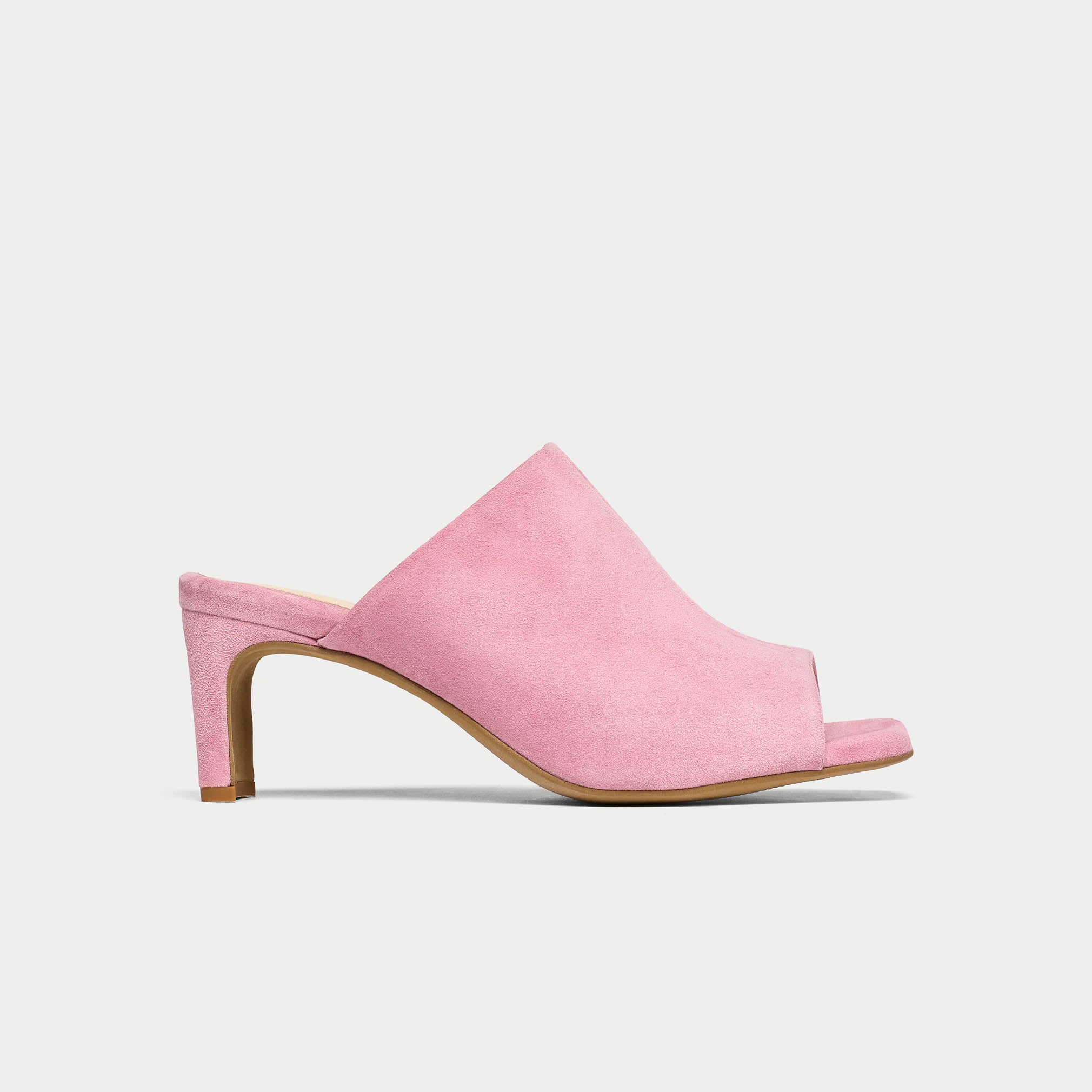 Pink suede mule shoe on a light gray background