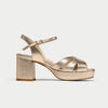 Gold high-heeled sandal on a light gray background