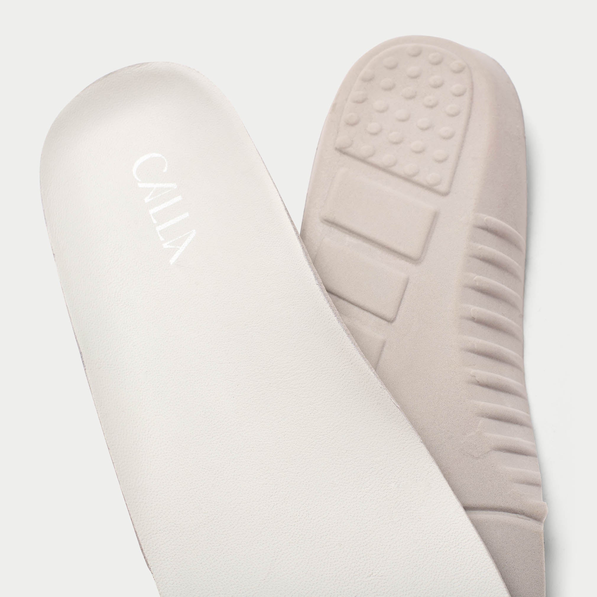 Close-up of beige insoles with 'Calla' branding on a light gray background