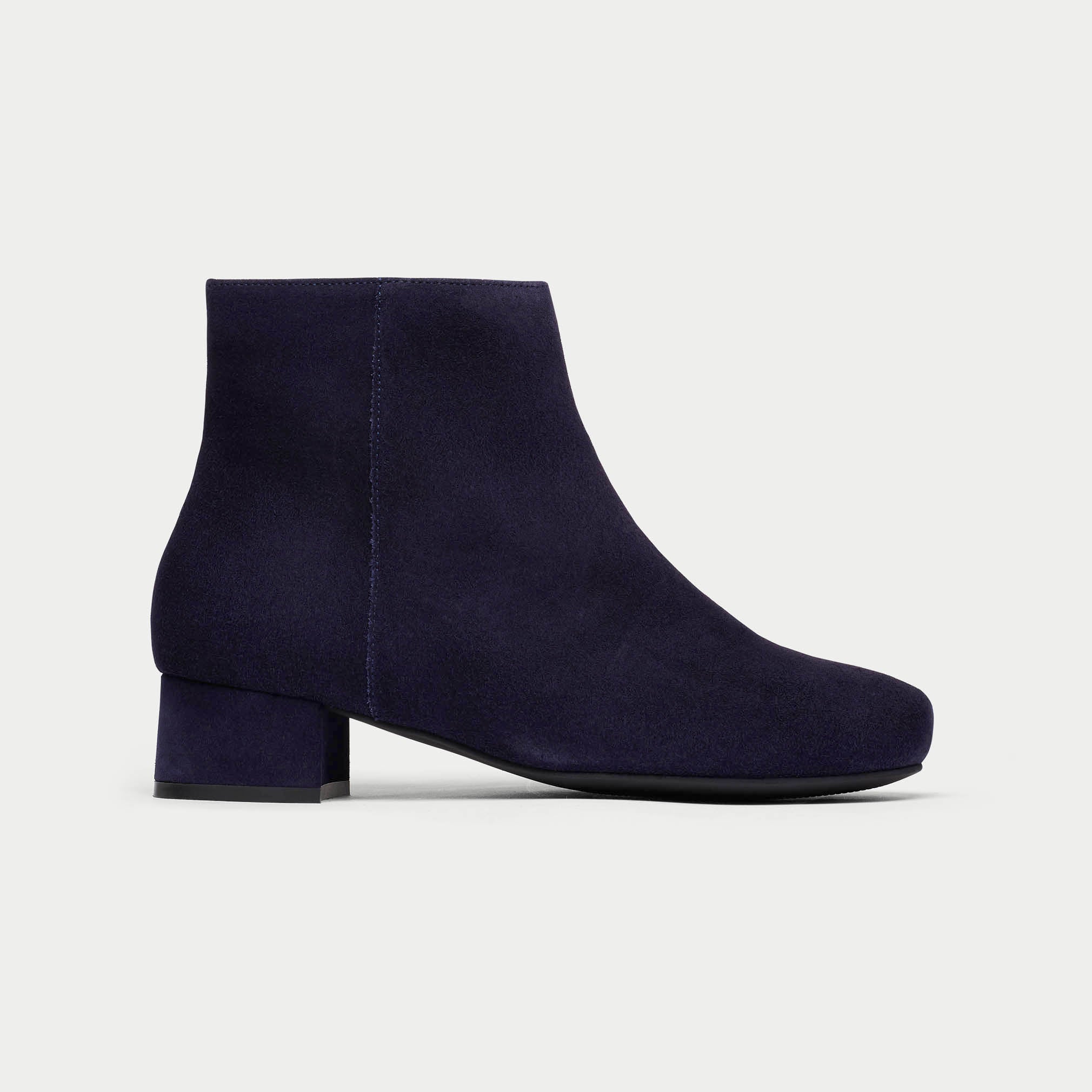 Navy blue ankle boot on a light gray background