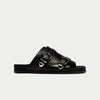 Black sandal with buckles on a light gray background