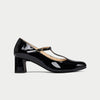 Black patent leather shoe with a strap on a light gray background