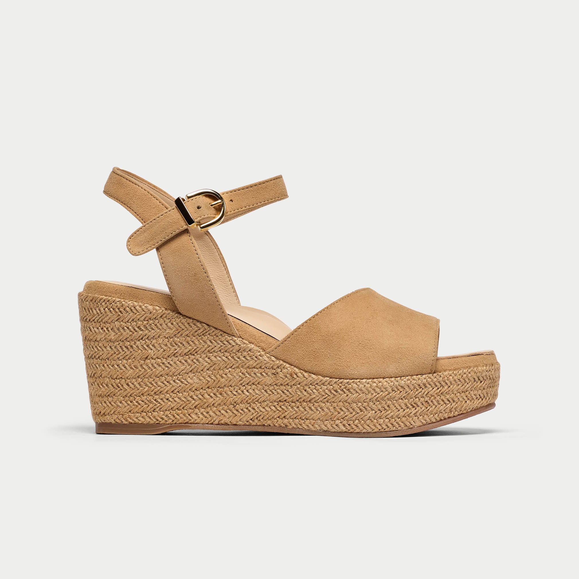 Tan wedge sandal with espadrille sole on a light gray background
