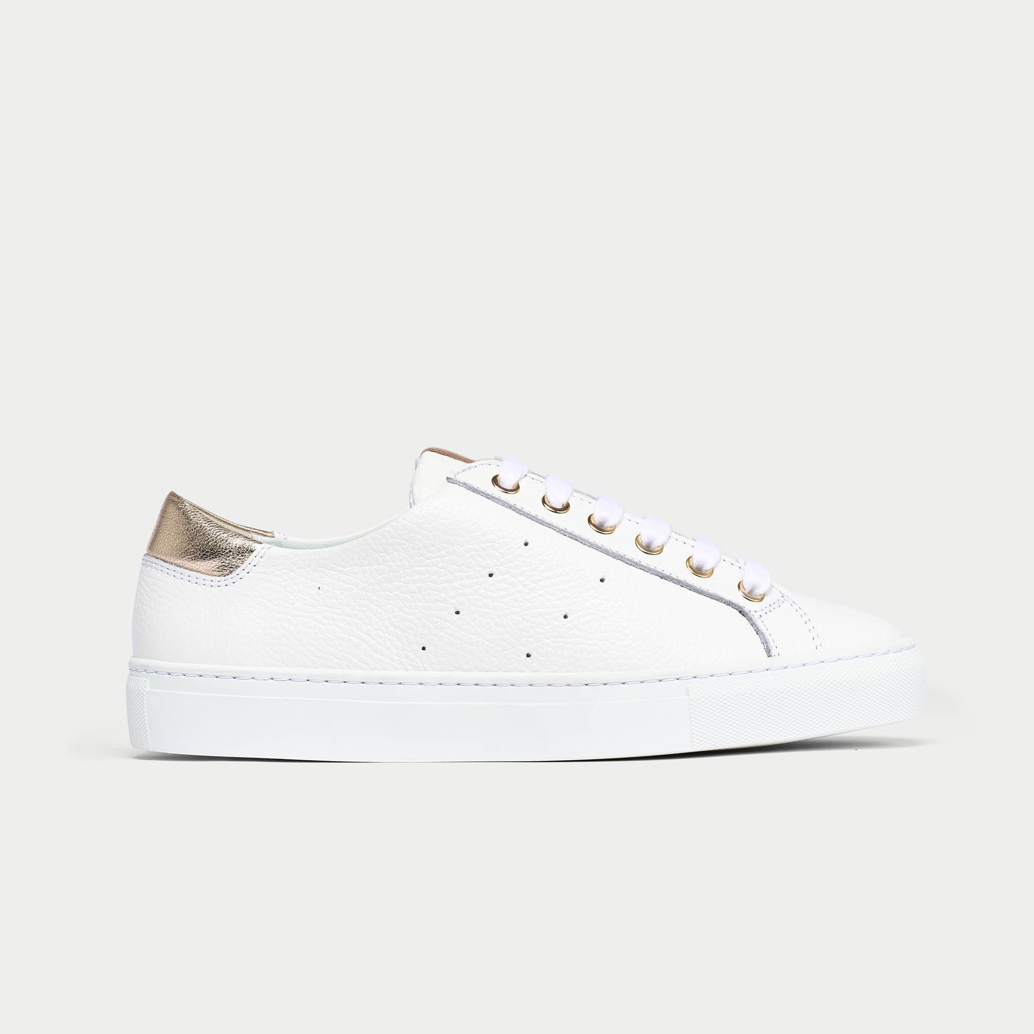 White sneaker with gold accents on a light gray background