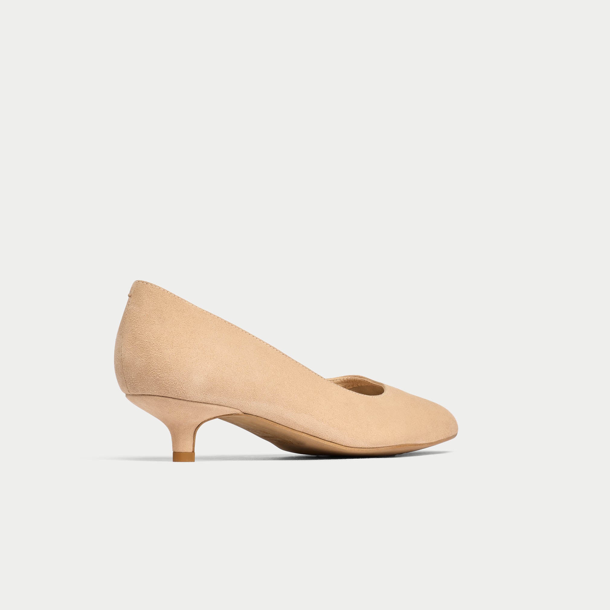 Beige low heel shoe on a light gray background
