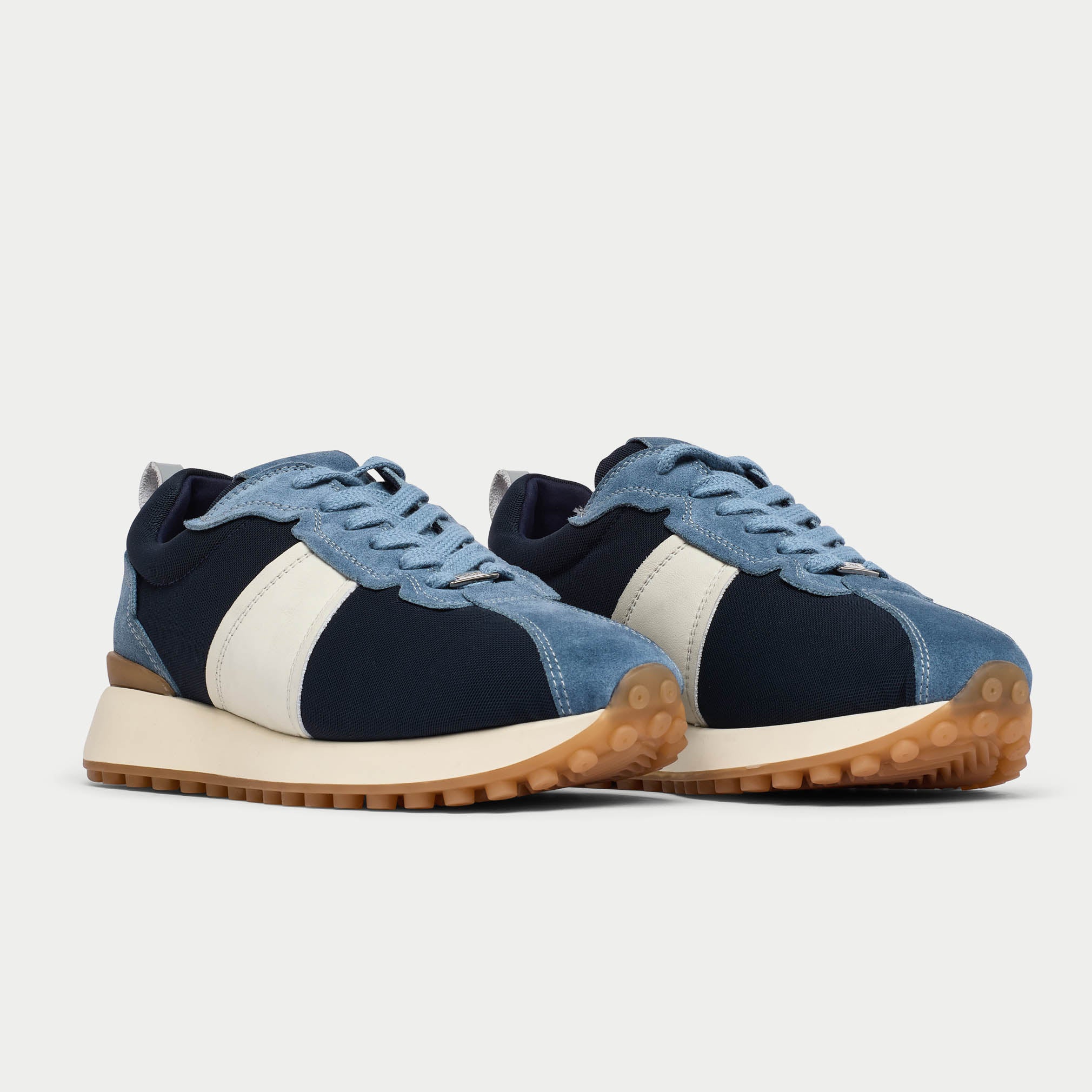 Pair of cosmos denim blue sneakers with white accents on a light gray background