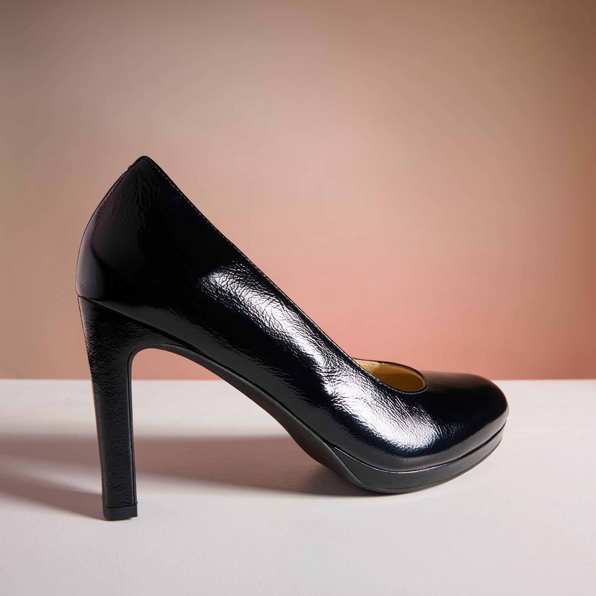 Black high-heeled shoe on a gradient background