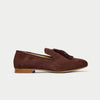 Brown suede loafer with tassel on a light gray background