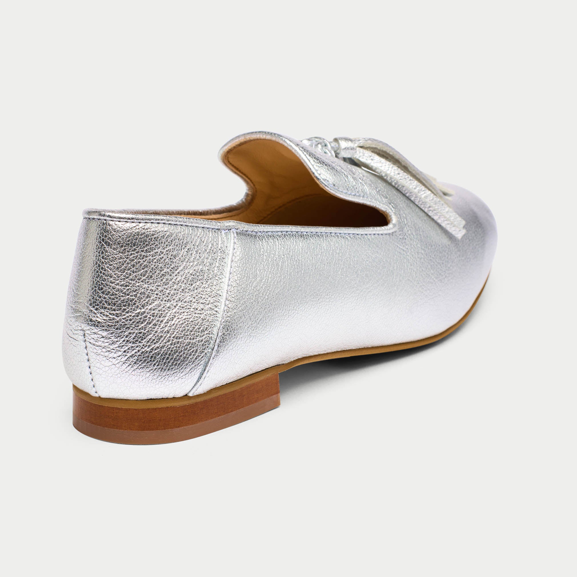 Silver loafer shoe on a light gray background