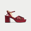 Red high-heeled sandal on a light gray background