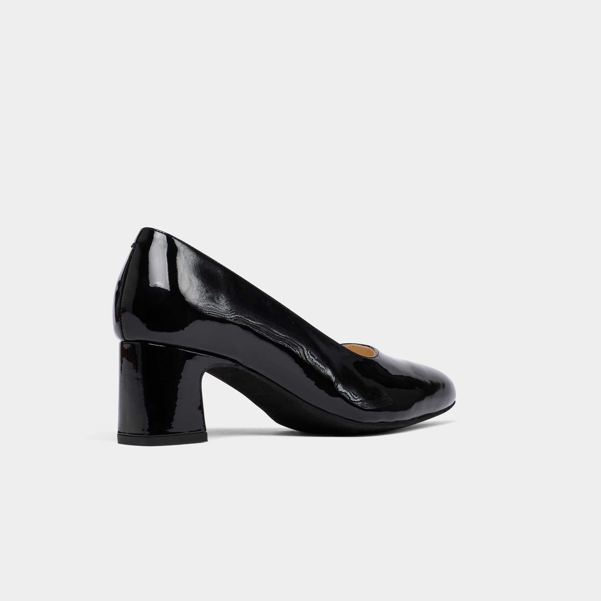 Black patent leather shoe on a light gray background