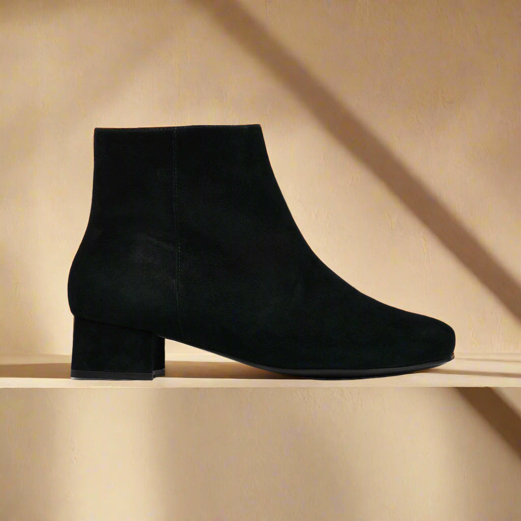 Lexie Black ankle boot on a light orange background