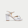 White sandal with block heel on a light gray background