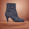Navy blue tweed Maya ankle boot on a light orange background