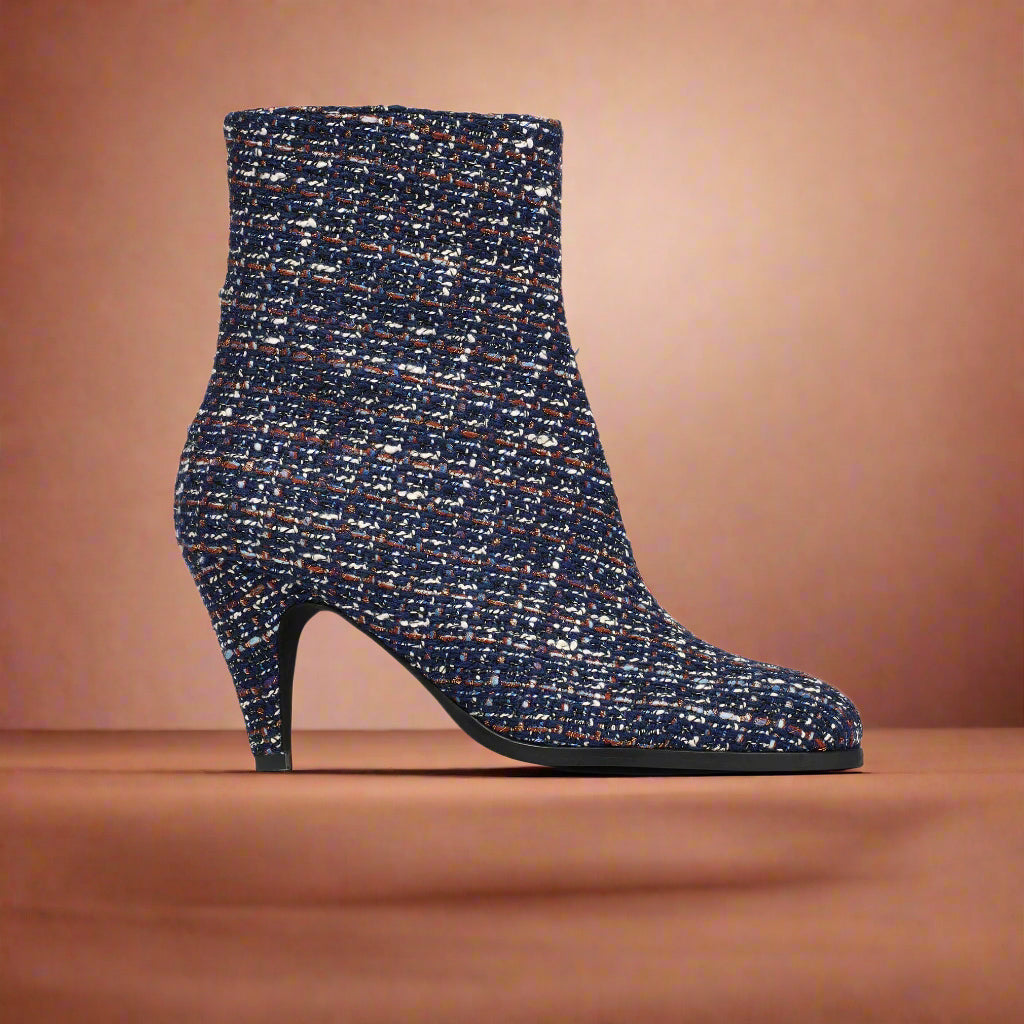 Navy blue tweed Maya ankle boot on a light orange background
