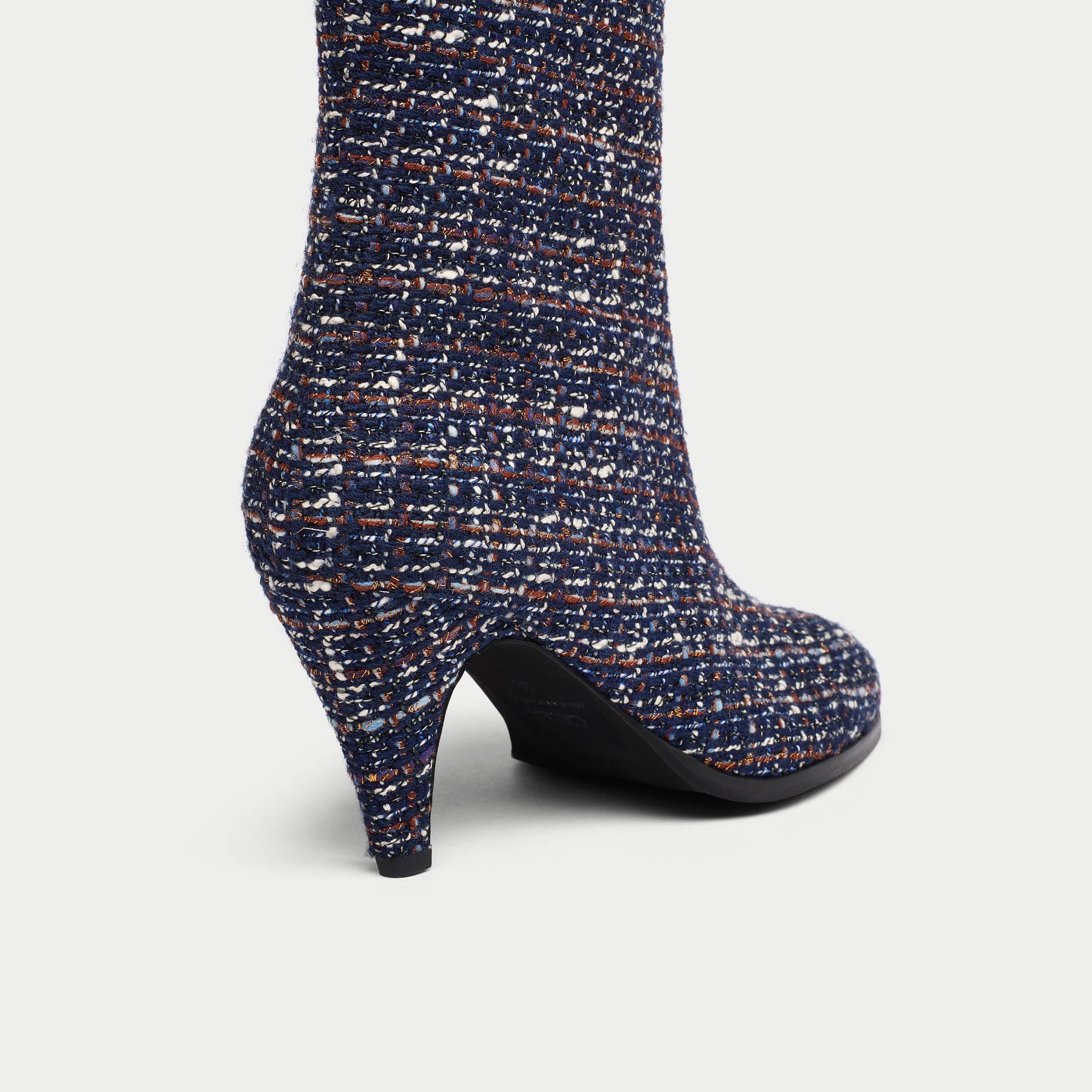 Navy blue tweed Maya ankle boot with a pattern of small white and brown dots on a light gray background heel close-up