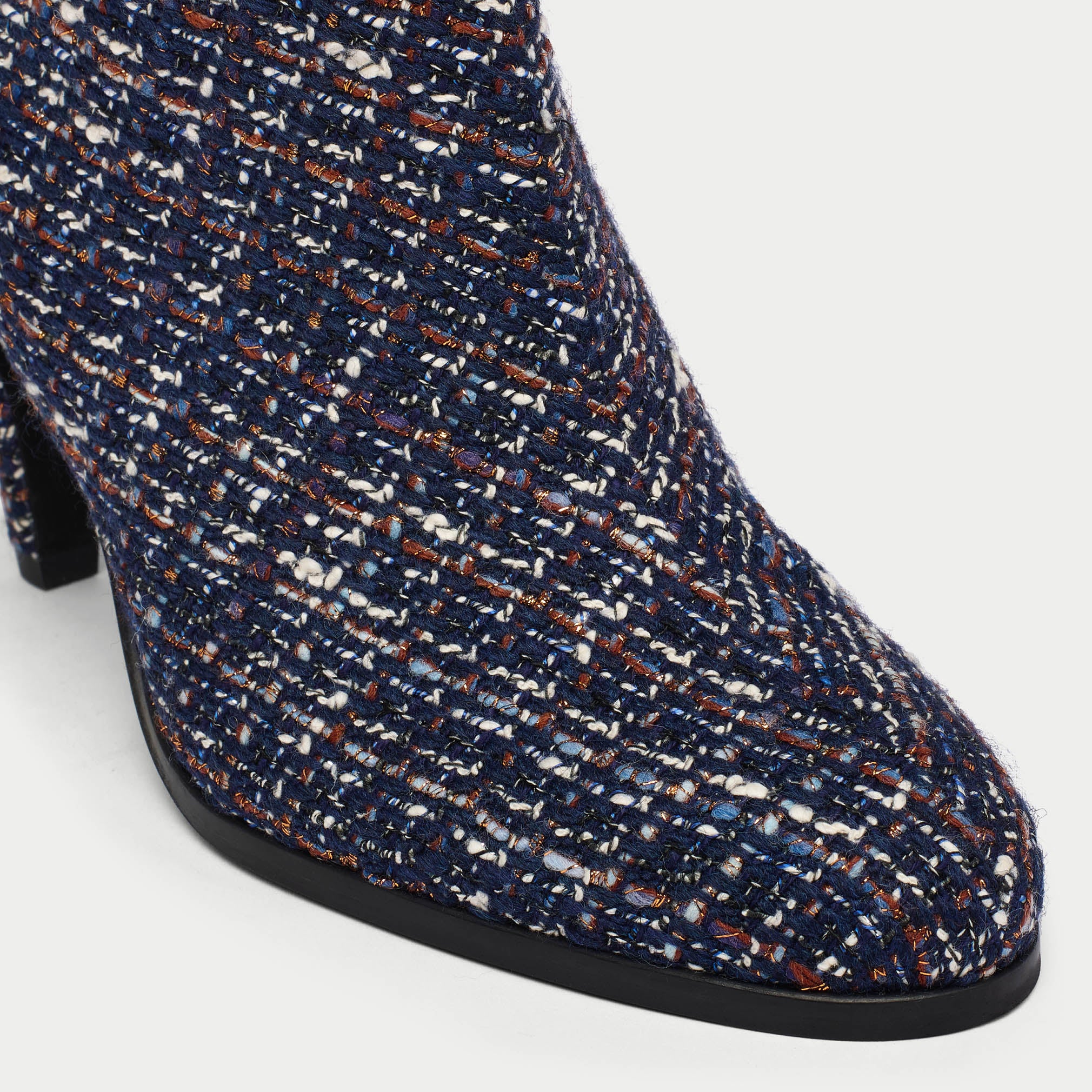 Navy blue tweed Maya ankle boot with a pattern of small white and brown dots on a light gray background tip close-up