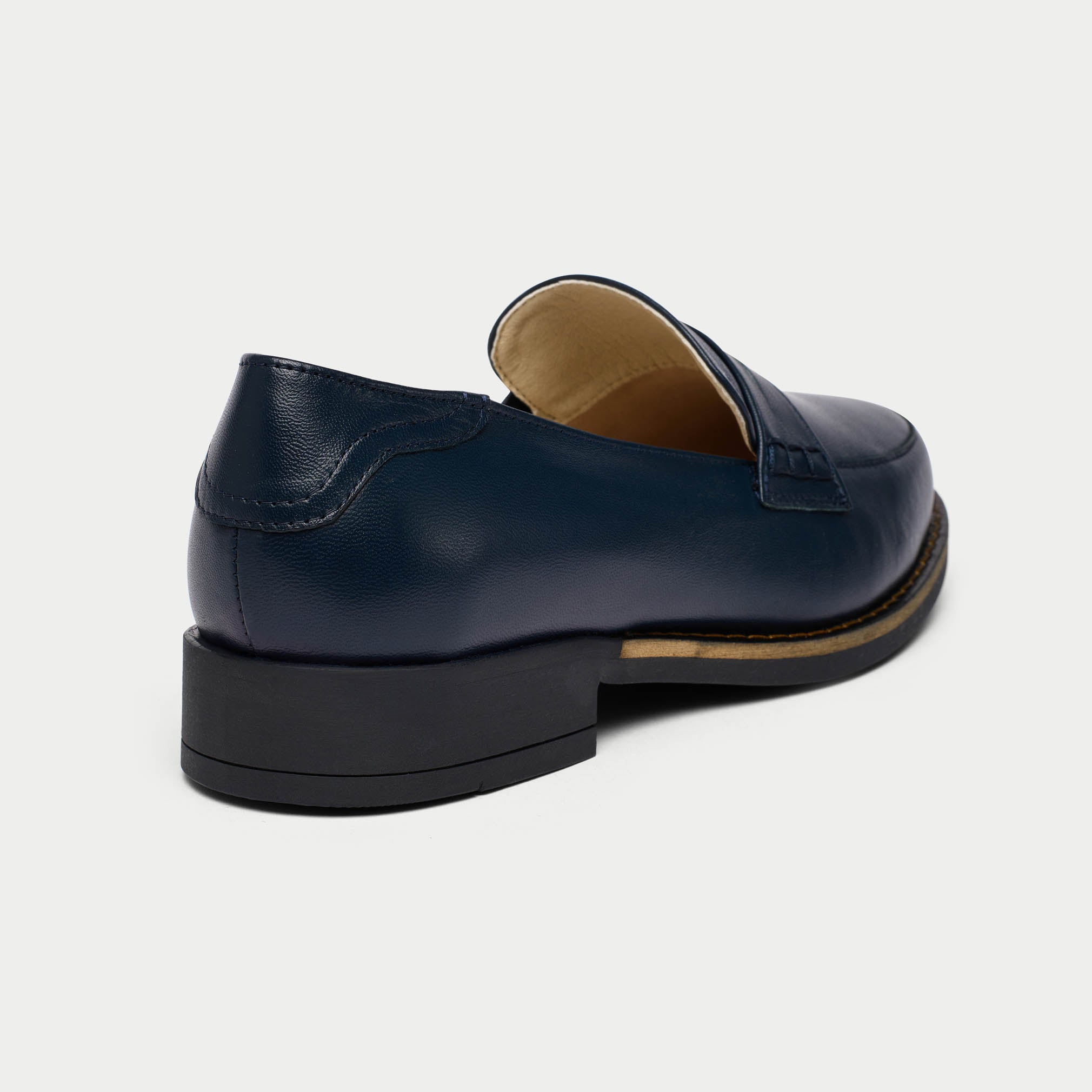 Navy blue loafer shoe on a light gray background