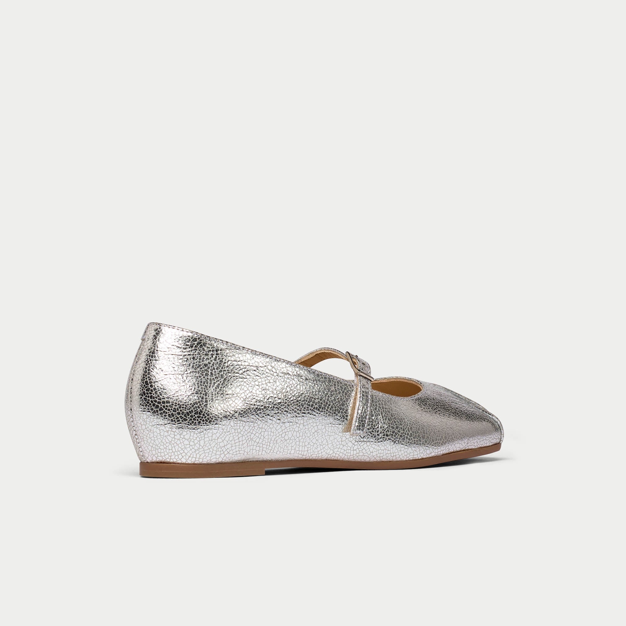 Silver metallic wedge shoe on a light gray background
