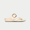 Beige sandal with a metallic buckle on a light gray background