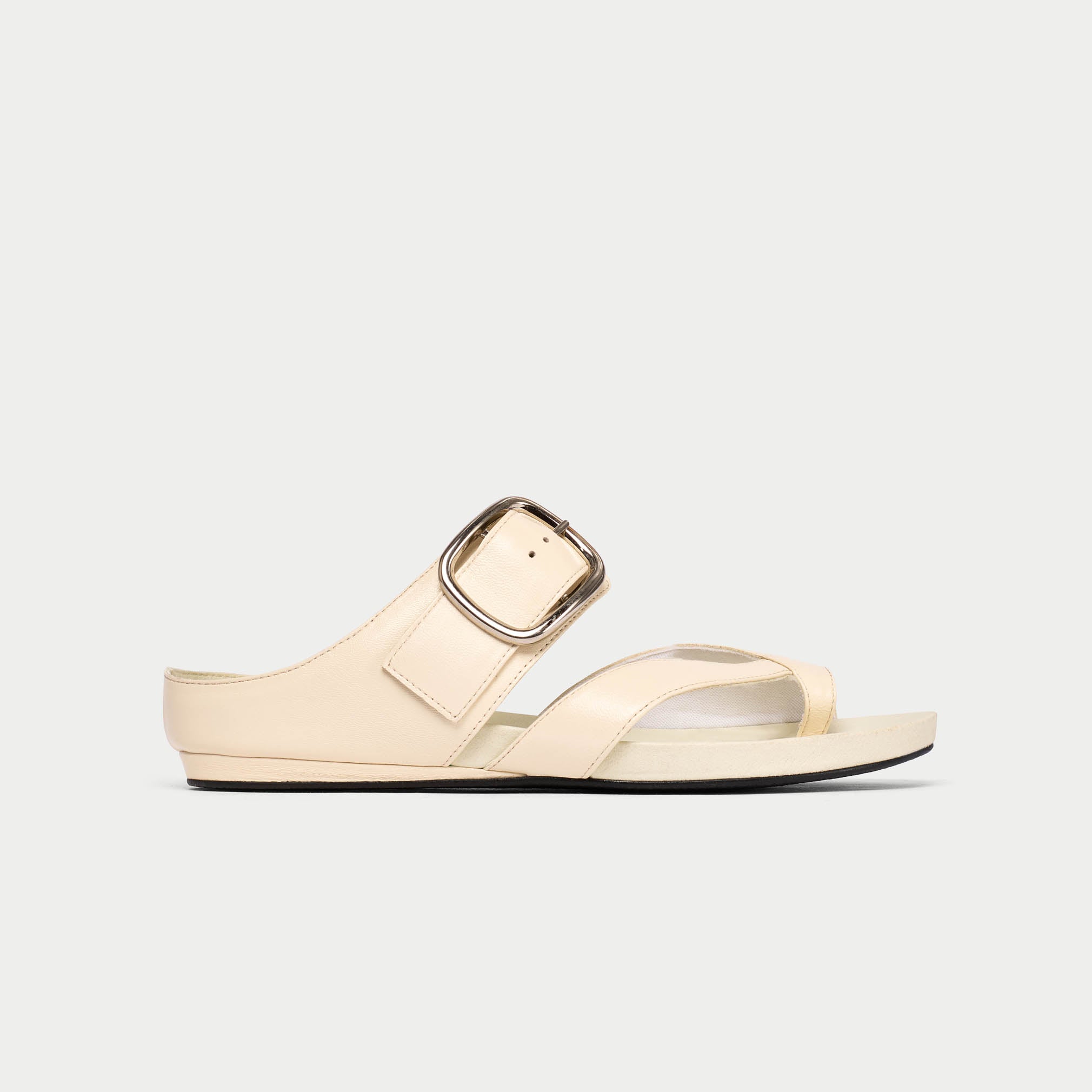 Beige sandal with a metallic buckle on a light gray background