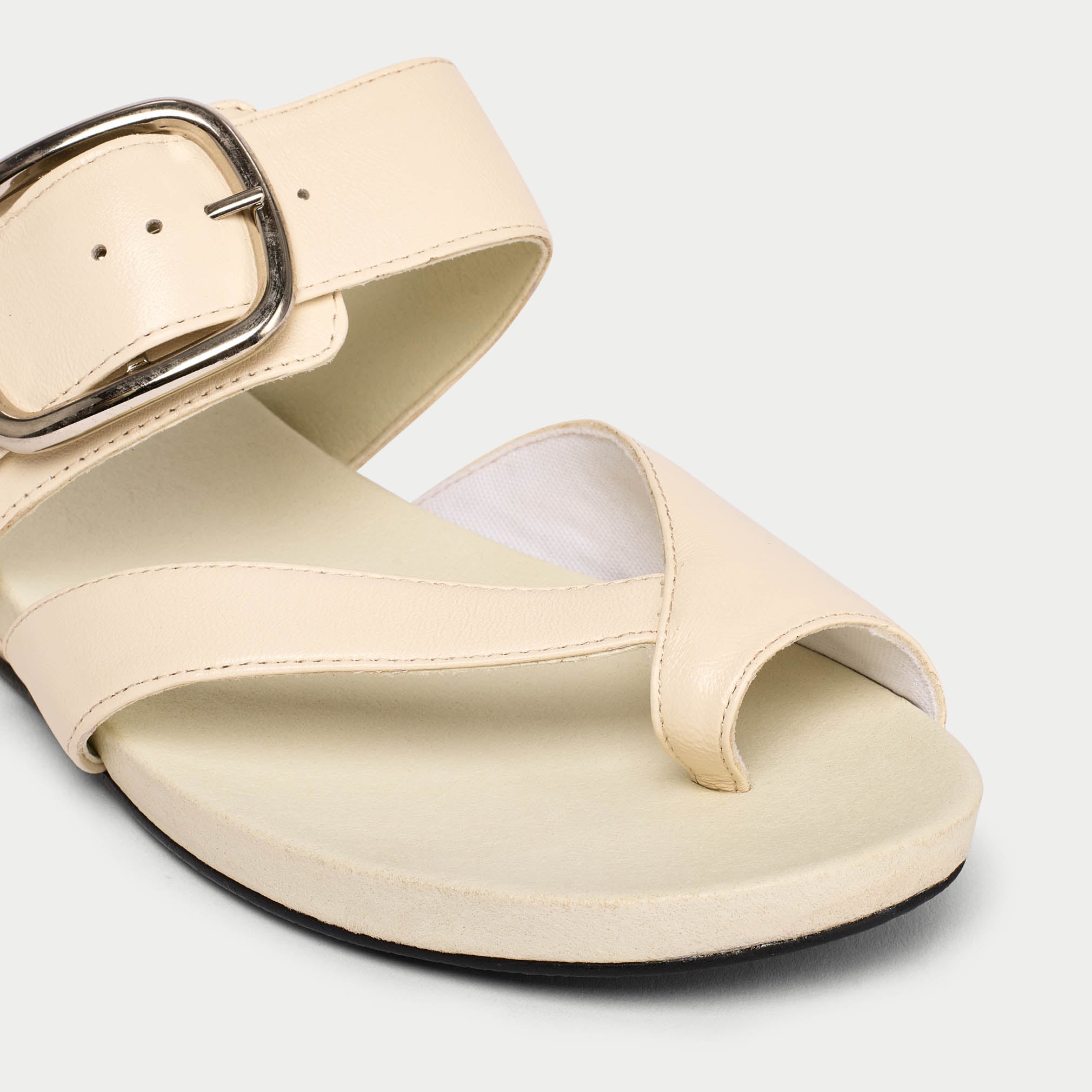 Beige sandal with a buckle on a light gray background