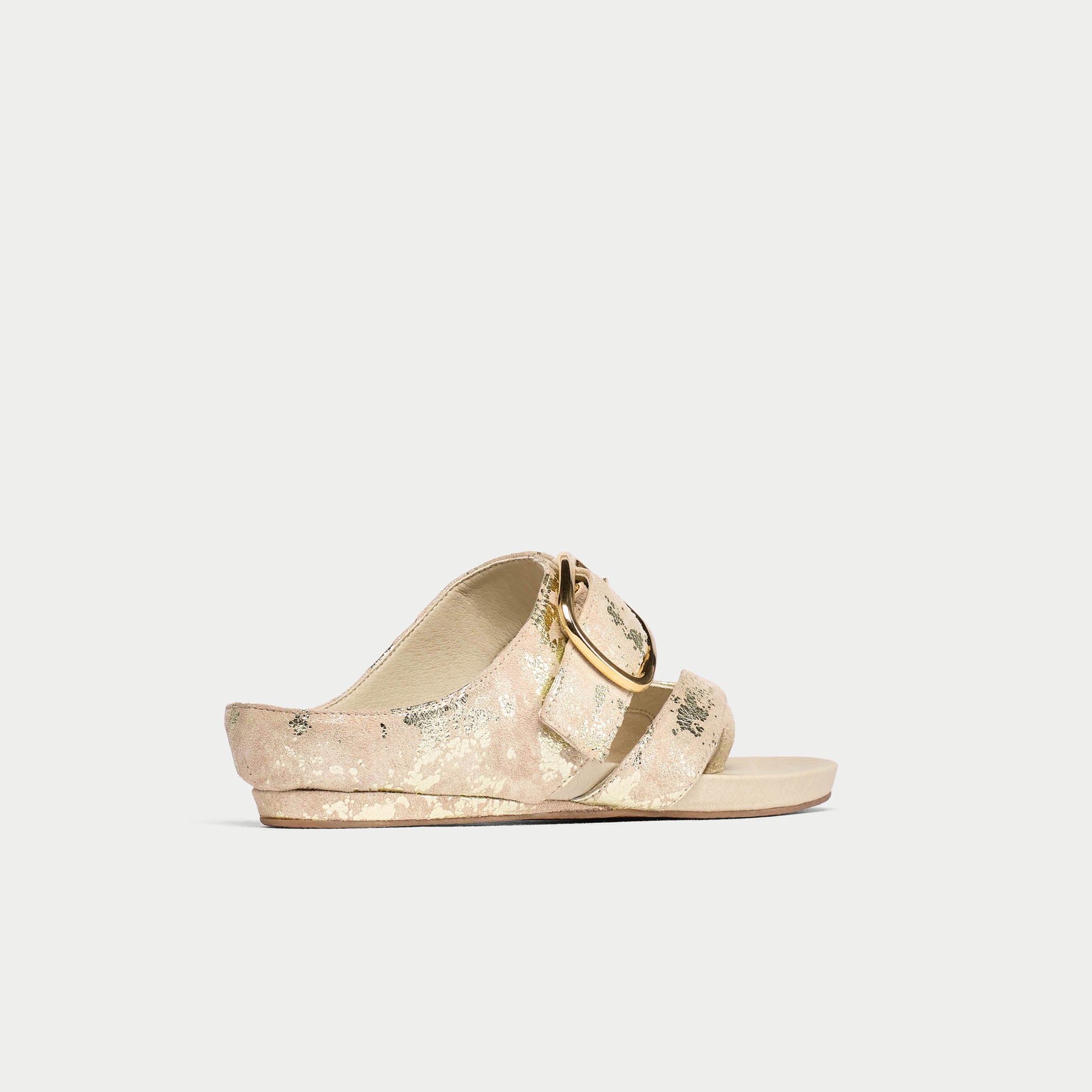 Beige sandal with gold buckle on a light gray background